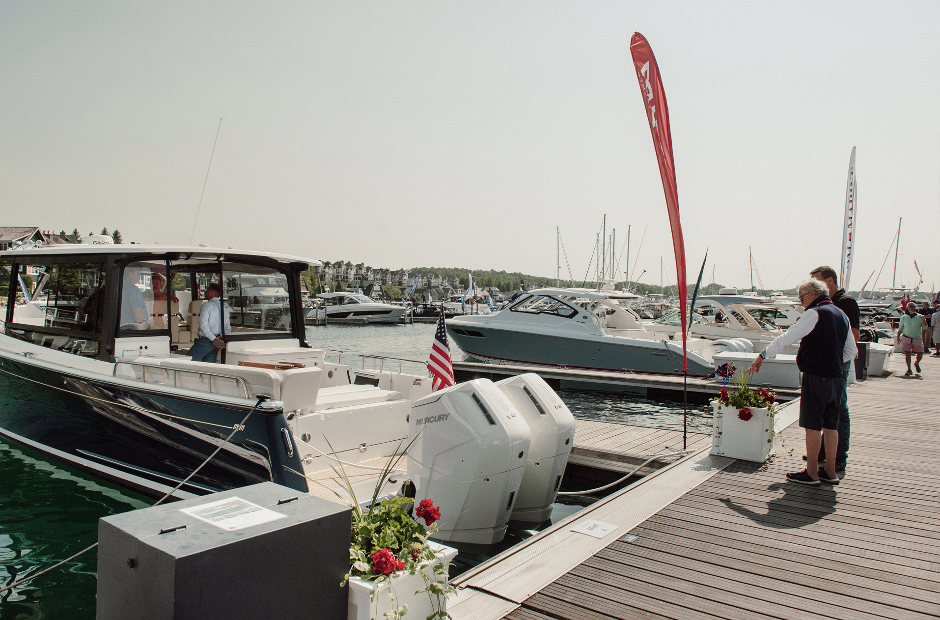 A couple standing next to a boat in a marina