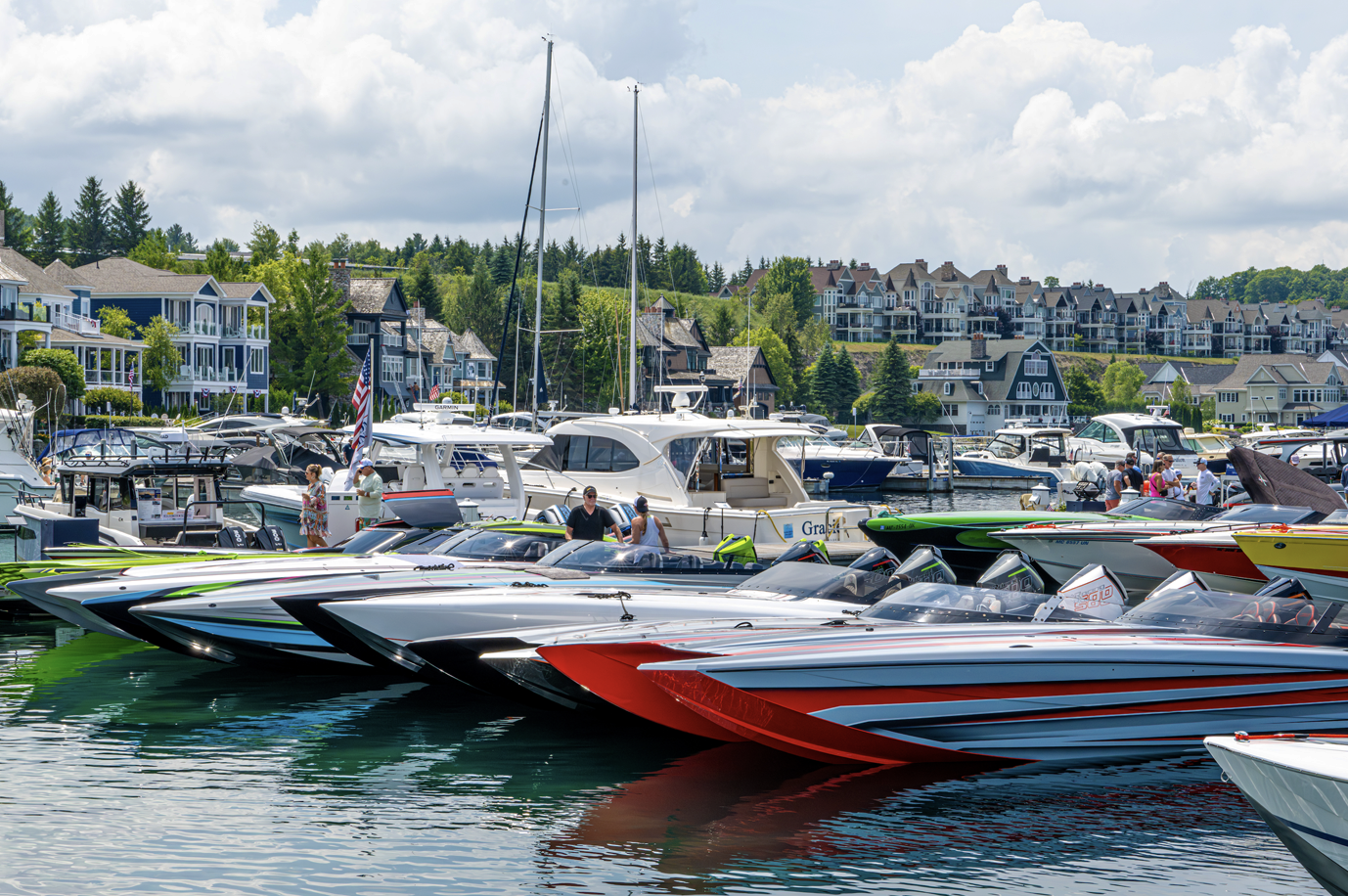 A row of speed boats are docked in a marina.