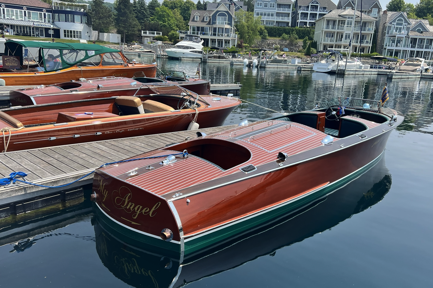 A wooden boat is docked at a dock next to a body of water.