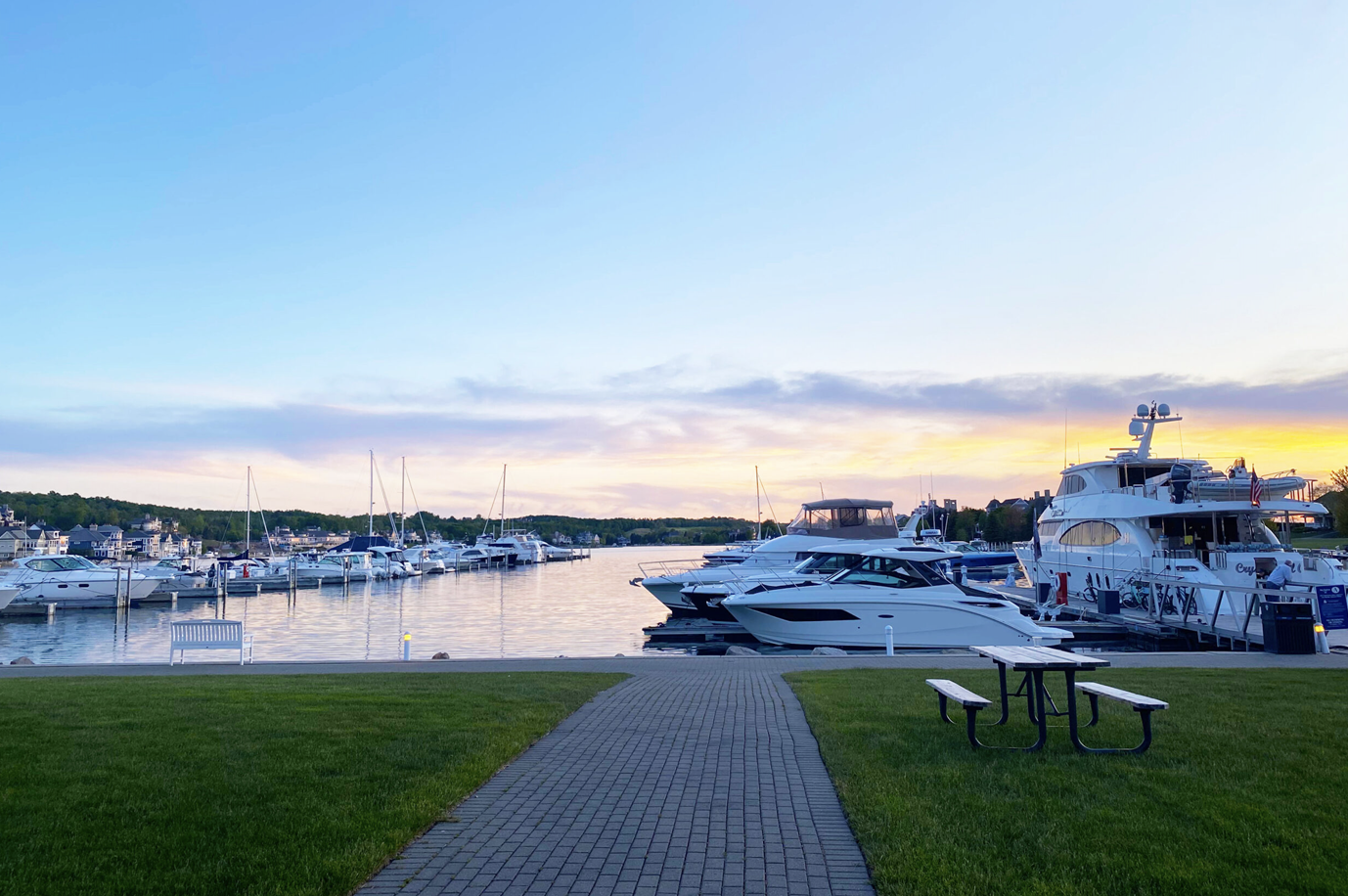 A marina with boats docked and a picnic table in the foreground.