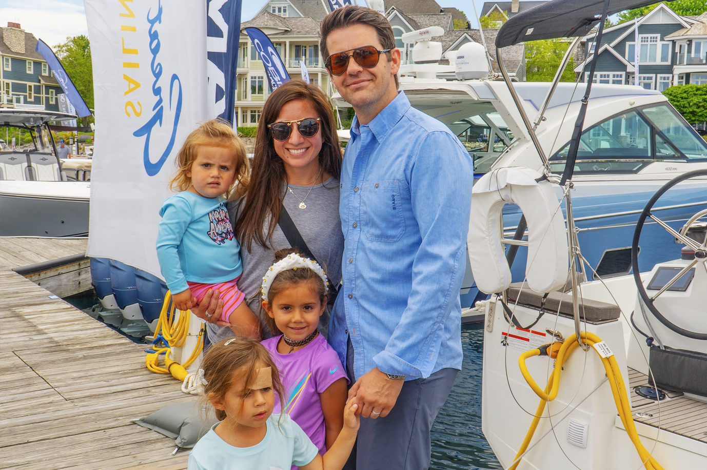 A family is posing for a picture in front of a boat.