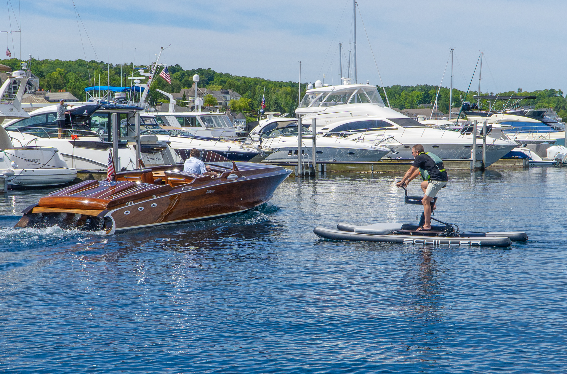 A man is riding a paddle board next to a boat in the water.
