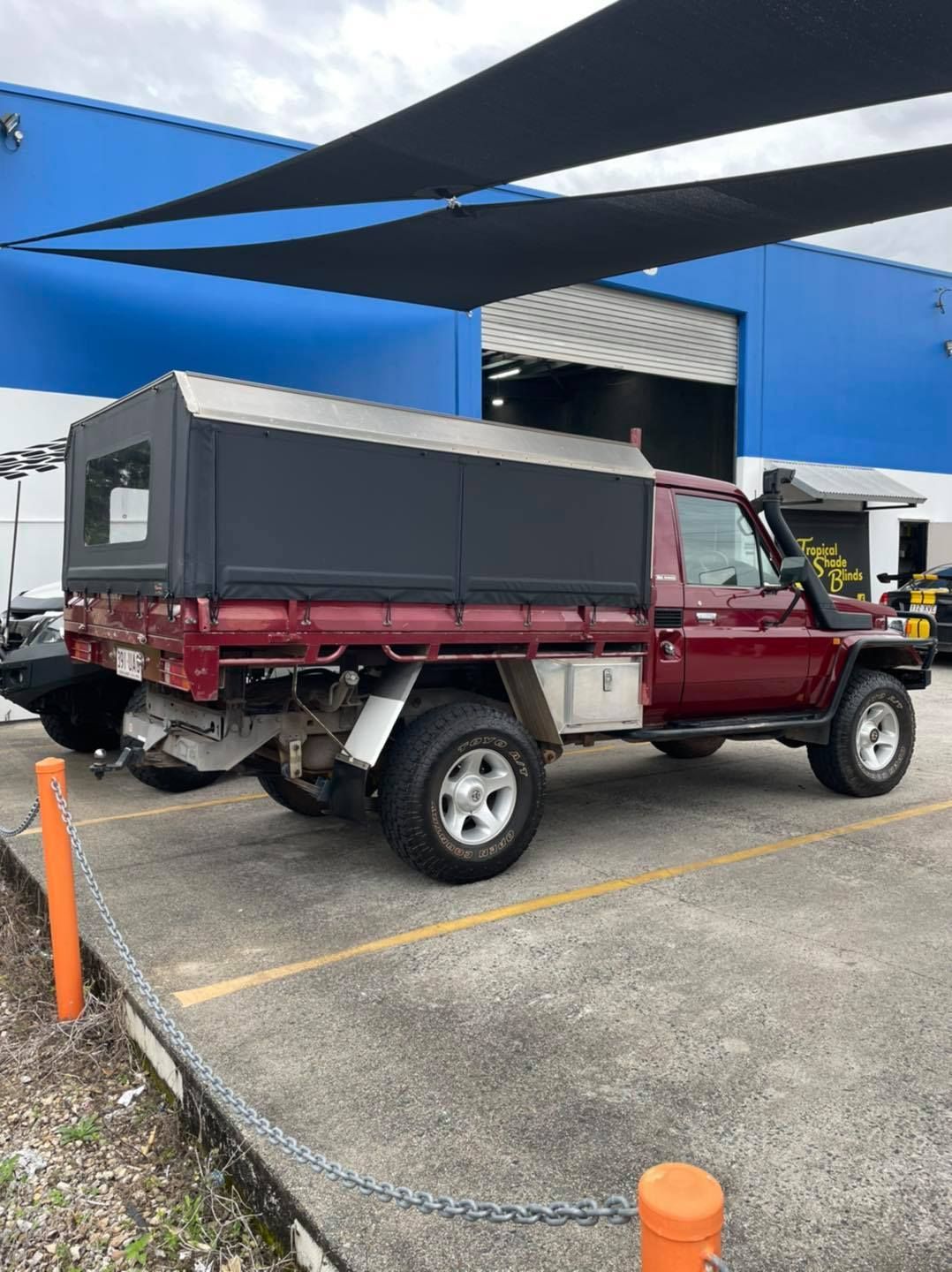 Red Truck With A Black Canopy Is Parked In A Parking Lot — Cairns Vinyl & Canvas in Bungalow, QLD