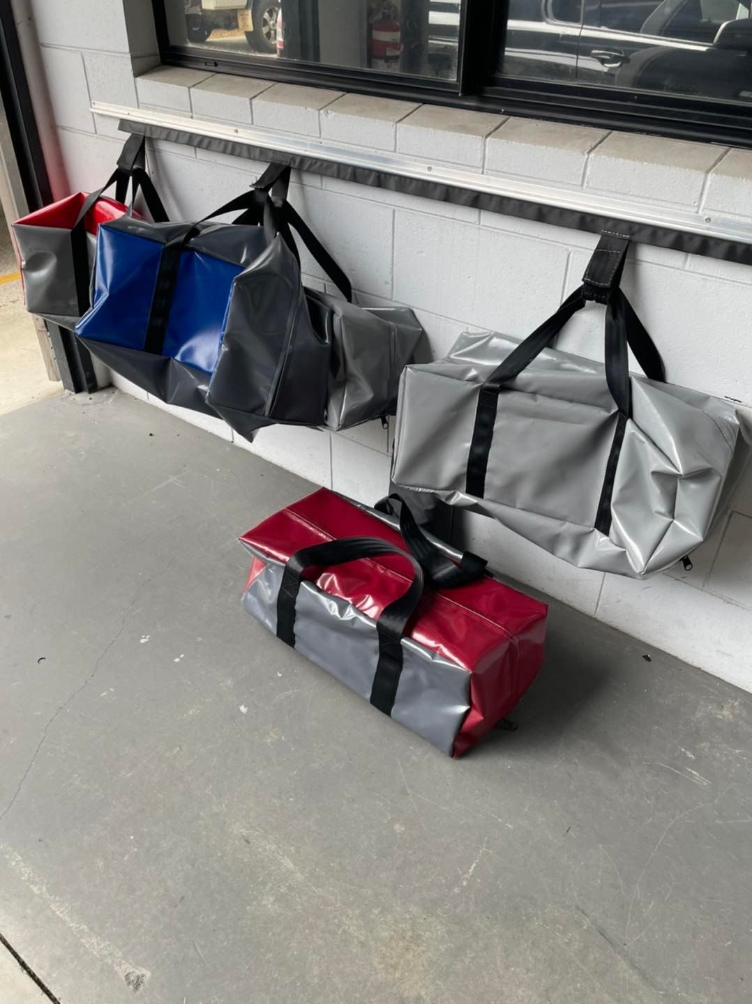 Row Of PVC Vinyl Bags Hanging On A Wall — Cairns Vinyl & Canvas in Bungalow, QLD