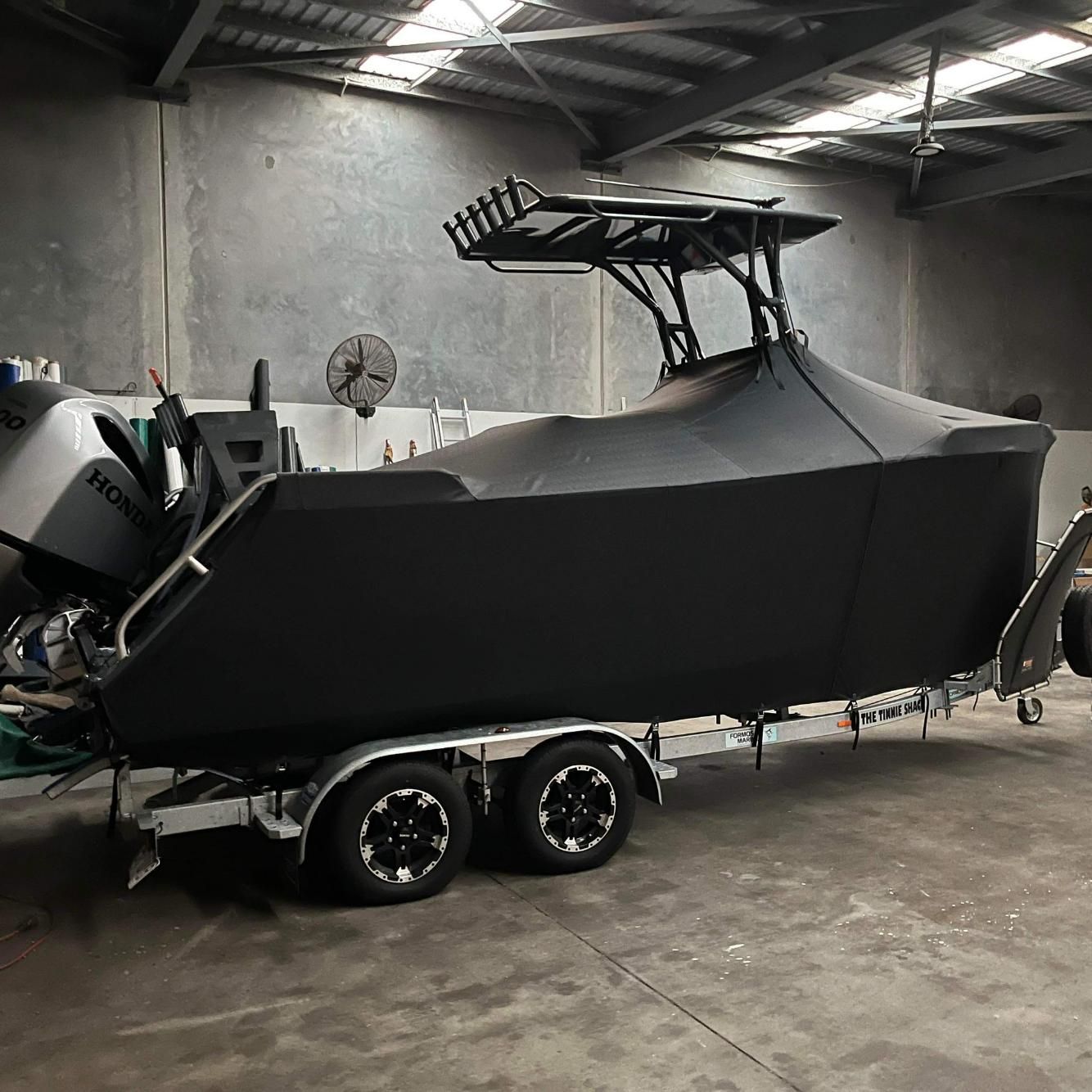 Boat With Black Cover Inside The Garage — Cairns Vinyl & Canvas in Bungalow, QLD
