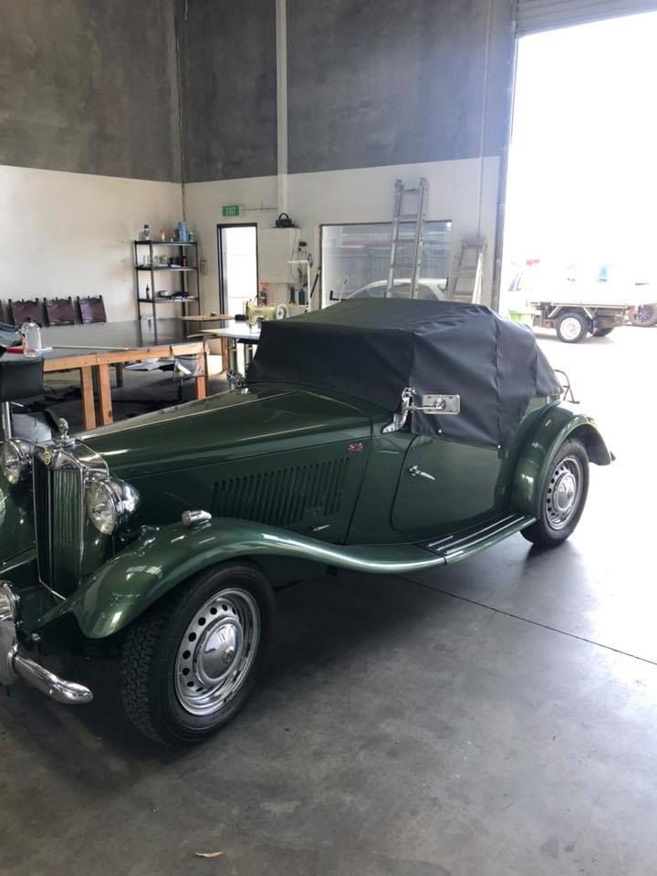 Green Car With A Black Top Is Parked In A Garage — Cairns Vinyl & Canvas in Bungalow, QLD