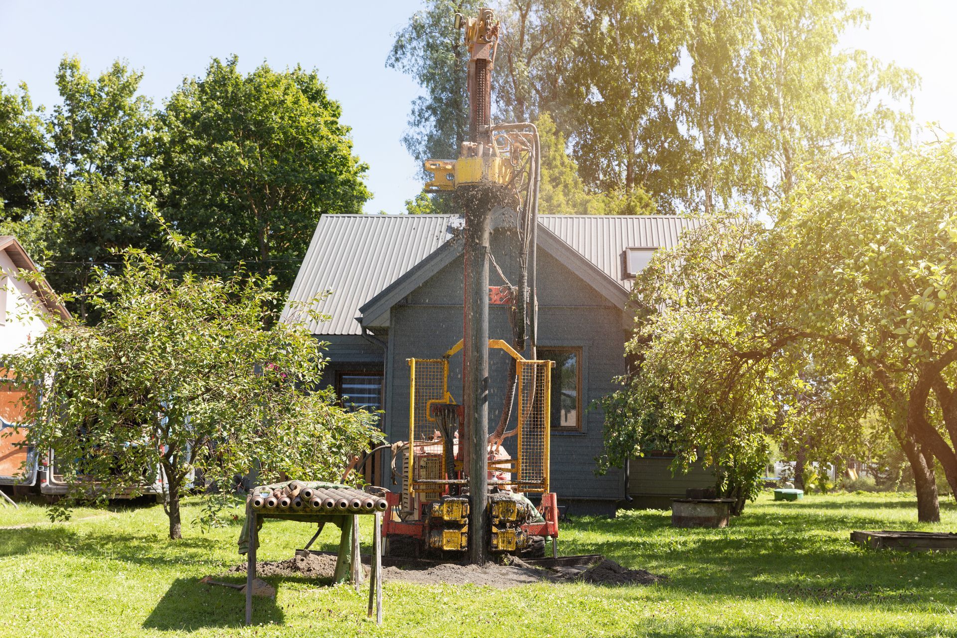 Drilling in ground an artesian well for groundwater, mud shooting out of tube, achieving clean water.