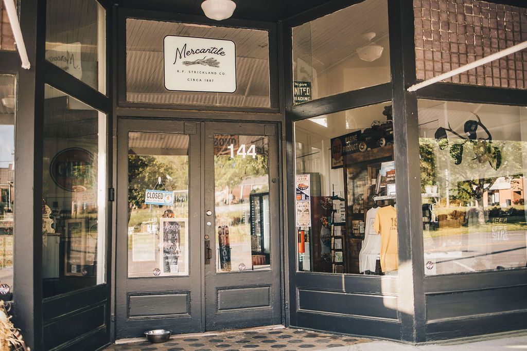A store front with a dog in front of it.