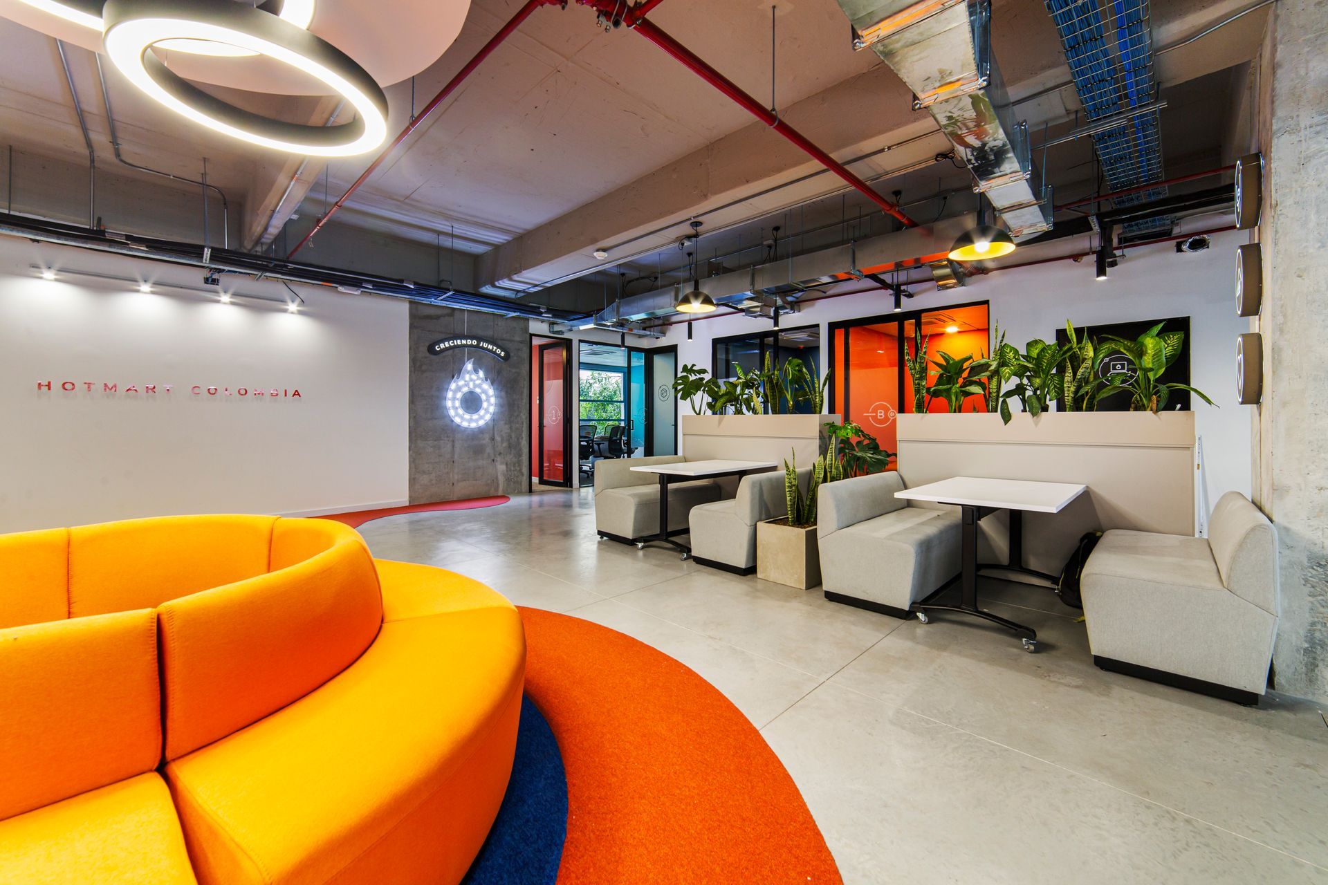 Una habitación con un sofá redondo y mesas.