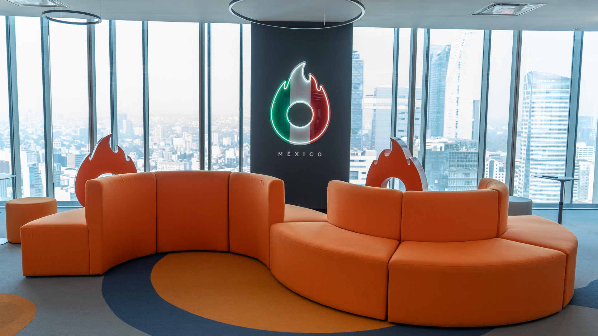 Un gran sofá naranja está situado delante de una gran ventana.