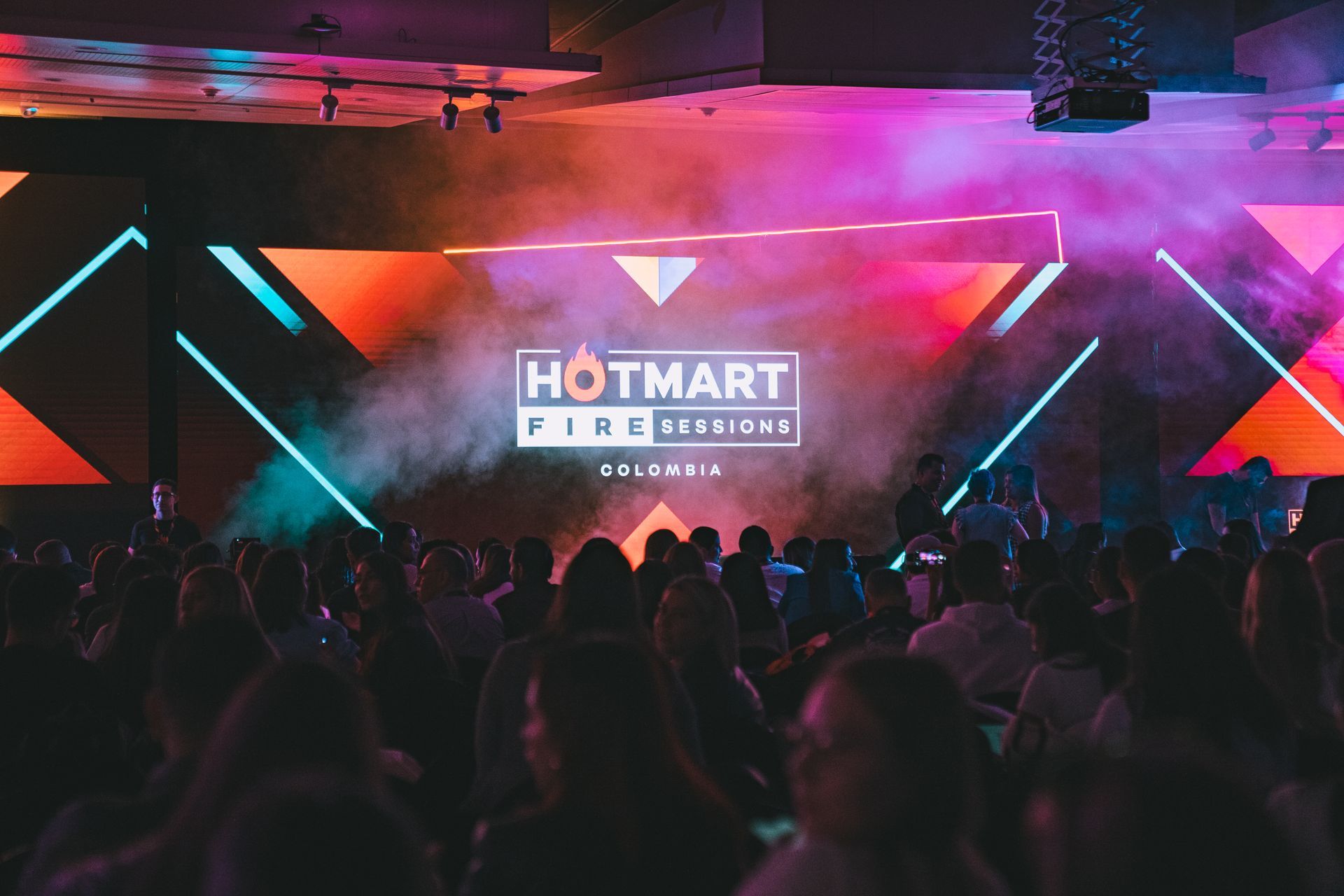 Escenario de Hotmart FIRE Sessions 2024 lleno con audiencia, luzes y humo artificial