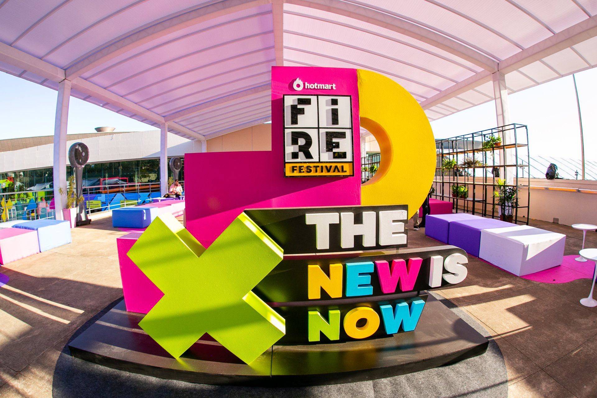 Uma placa colorida que diz o novo é agora está na frente de um prédio.