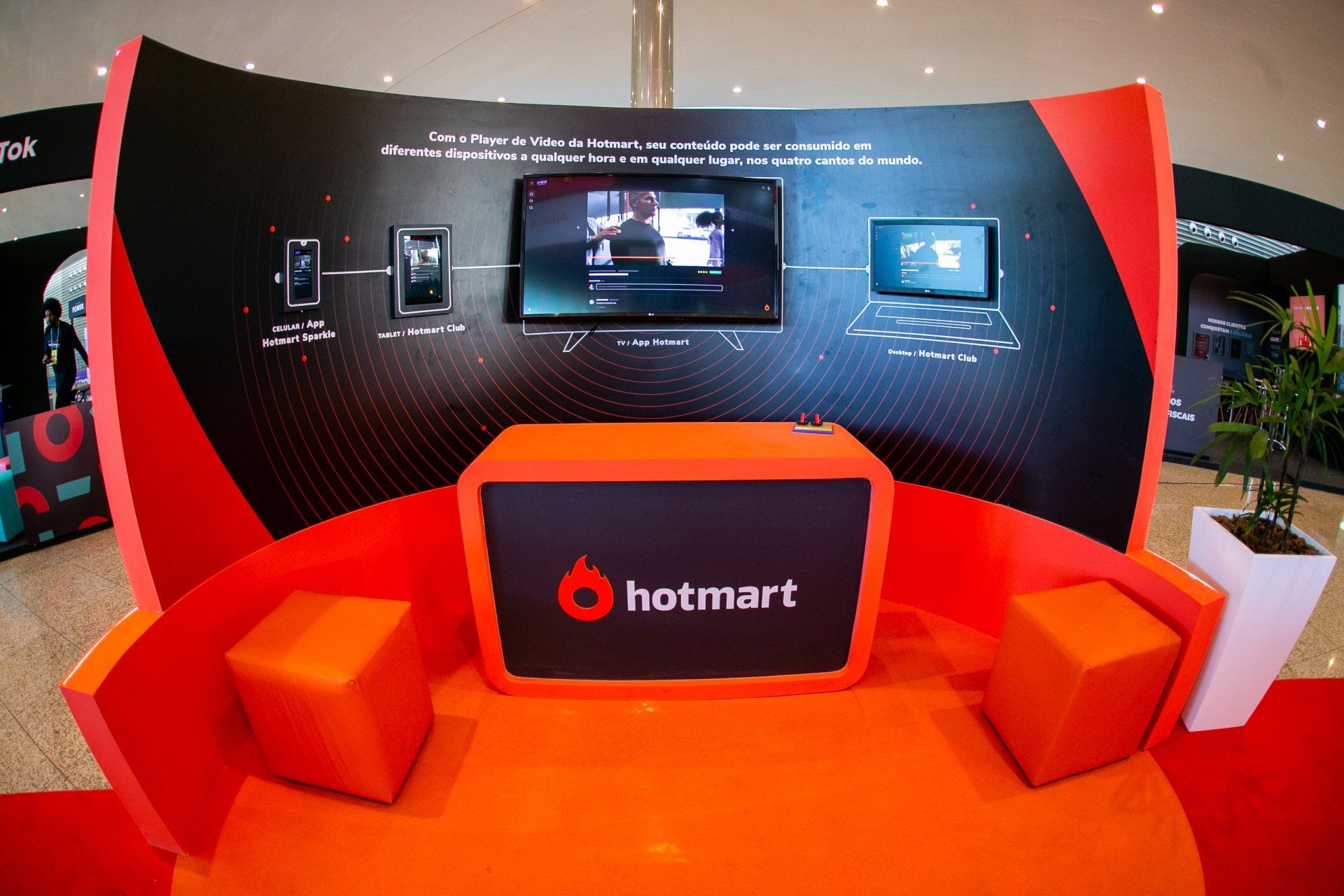Um estande hotmart com mesa e cadeiras