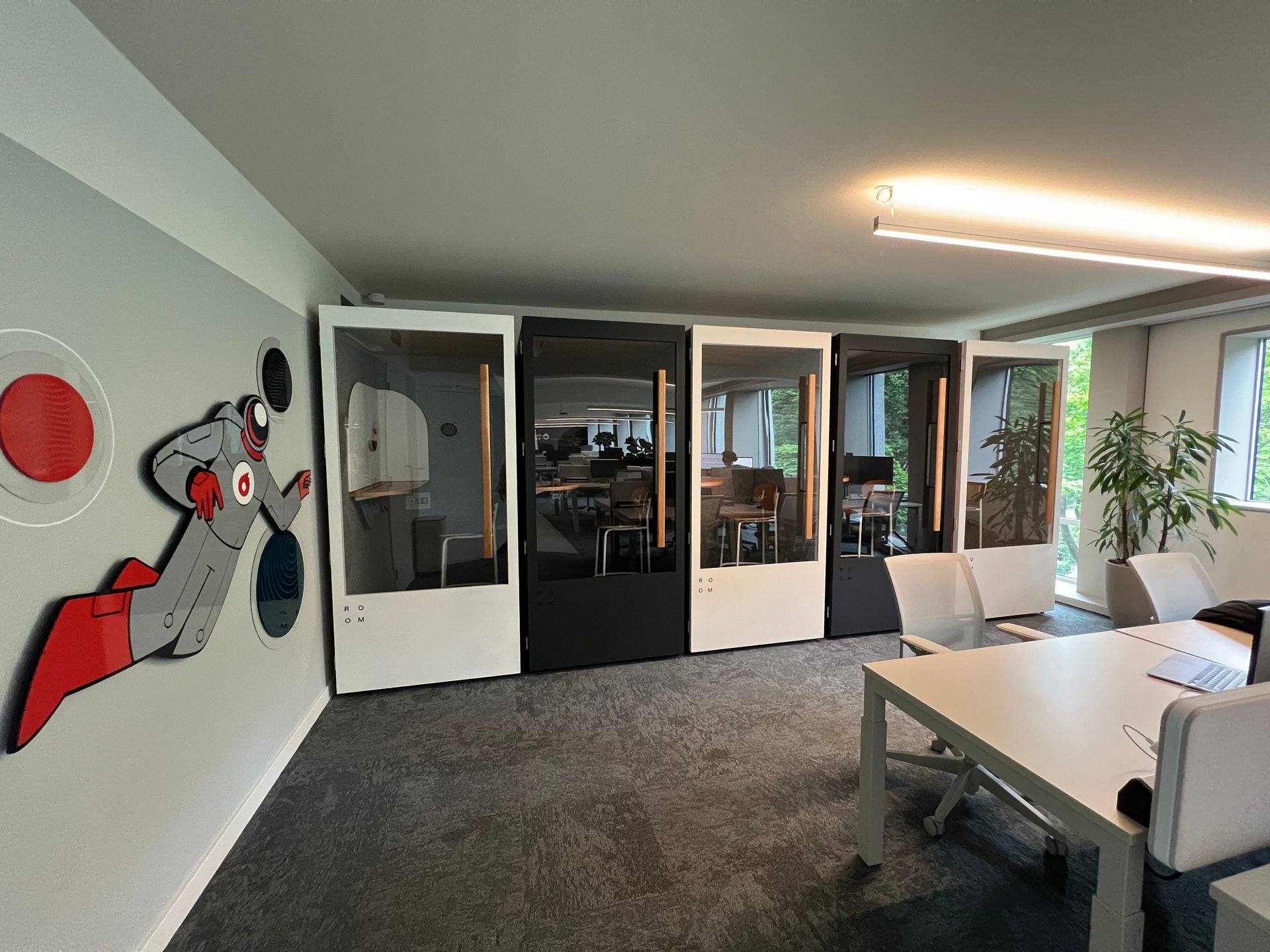 Una habitación con una mesa, sillas y un cuadro en la pared.