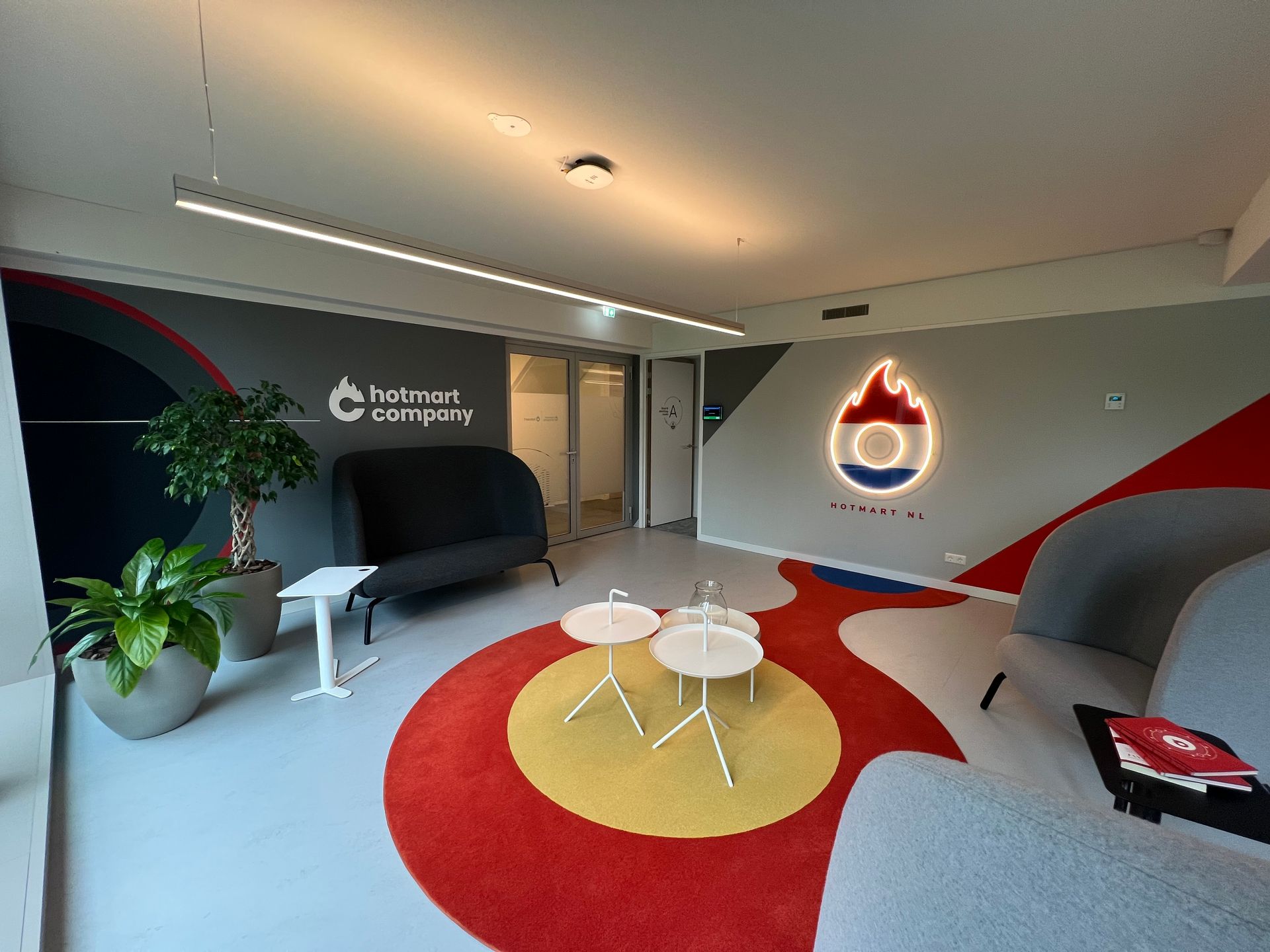 Una sala de estar con un sofá, mesas y una alfombra roja y amarilla.