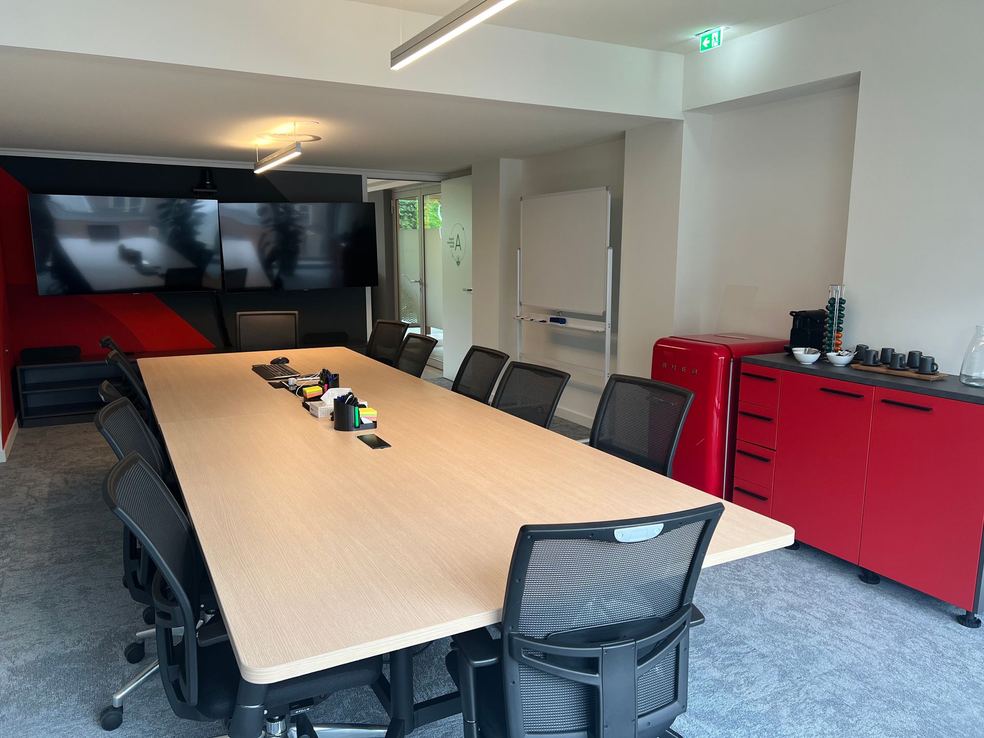 Una sala de conferencias con una mesa larga y sillas.