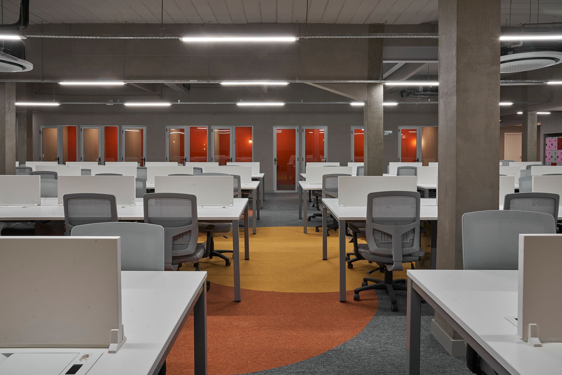 Una oficina grande con muchos escritorios y sillas.