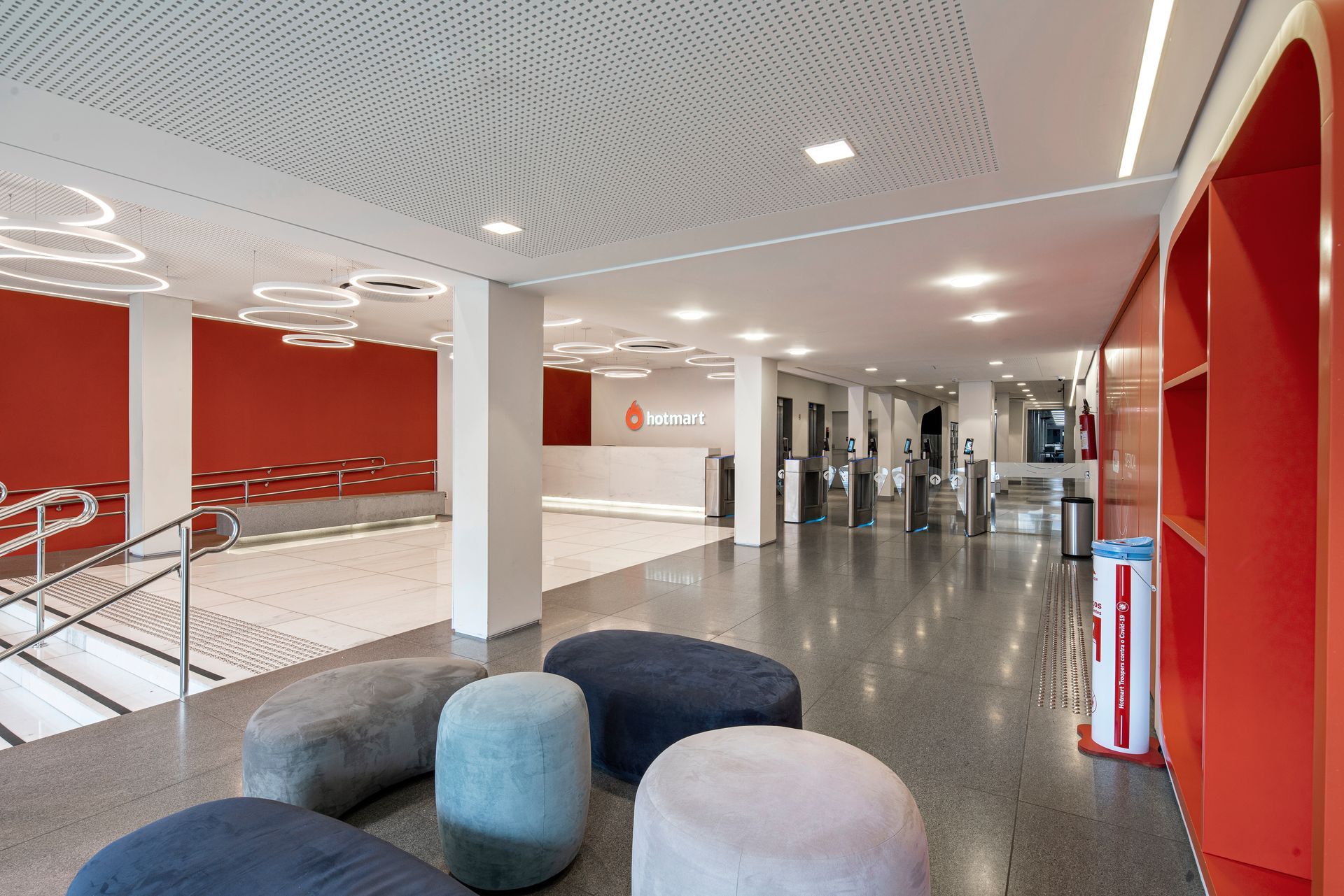 Hay muchos otomanos en el vestíbulo de un edificio.