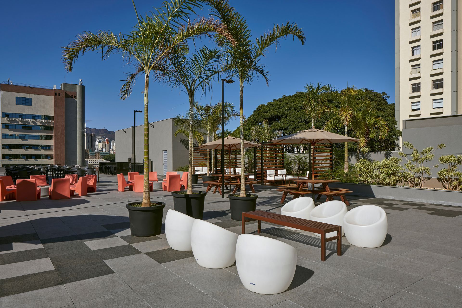 Un patio con sillas y sombrillas frente a un edificio.