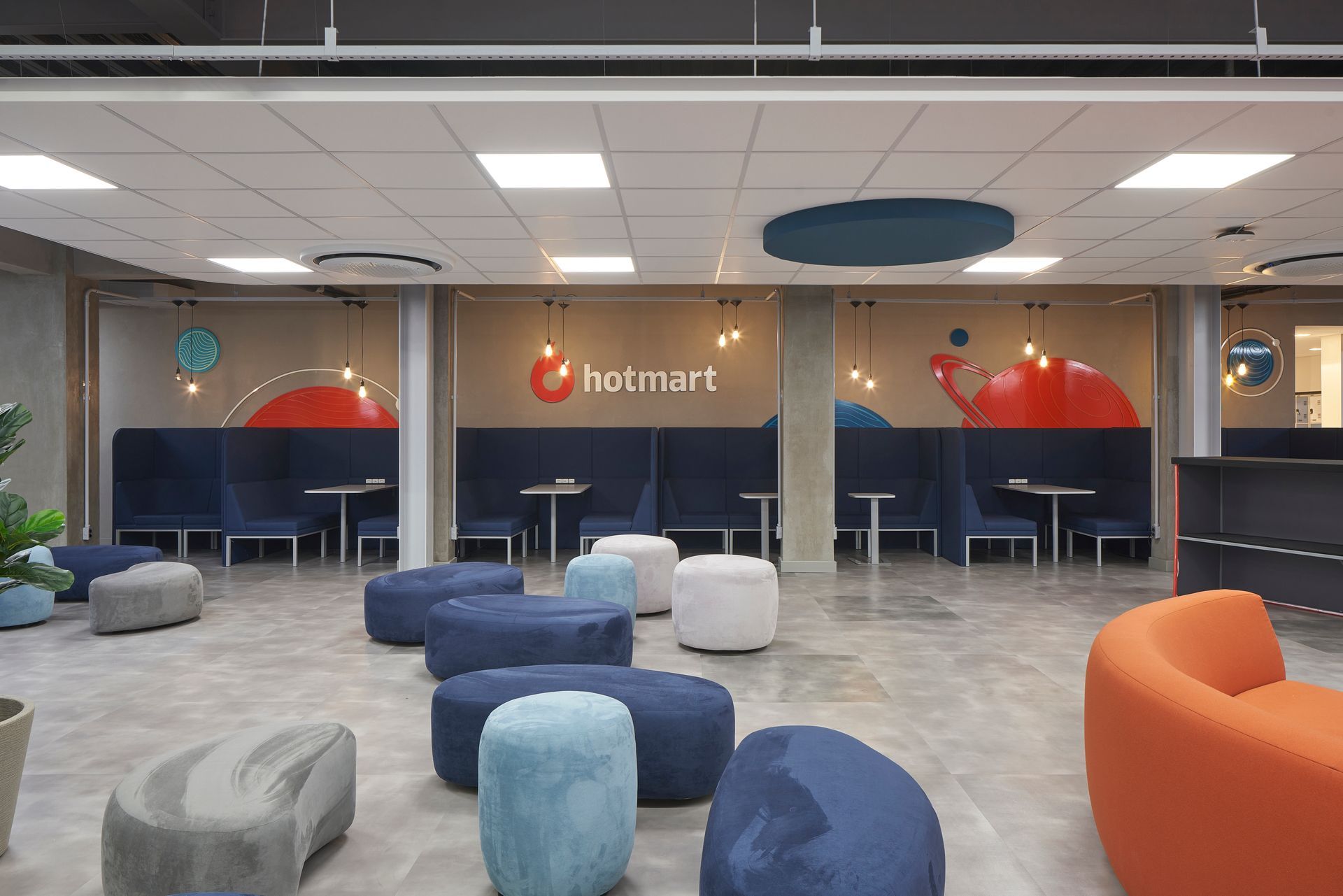 Una habitación grande con muchos muebles y mesas de colores.