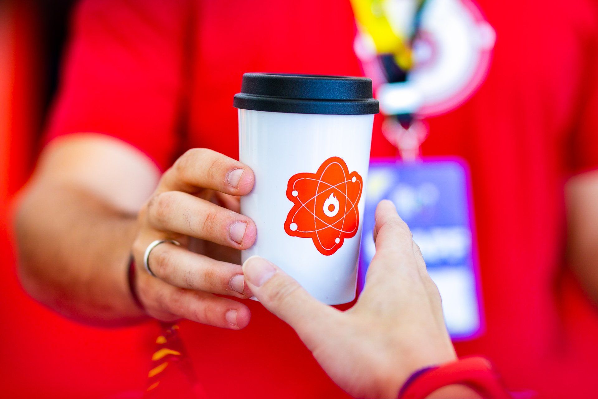 Uma pessoa está segurando uma xícara de café com um átomo nela.