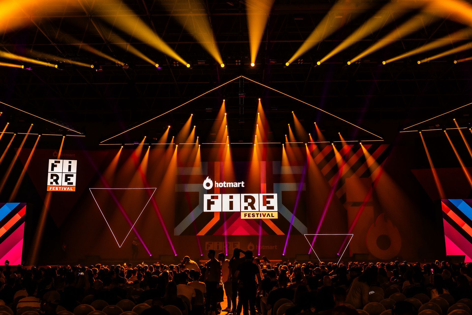 Uma multidão de pessoas se reúne em frente a um palco que diz puro