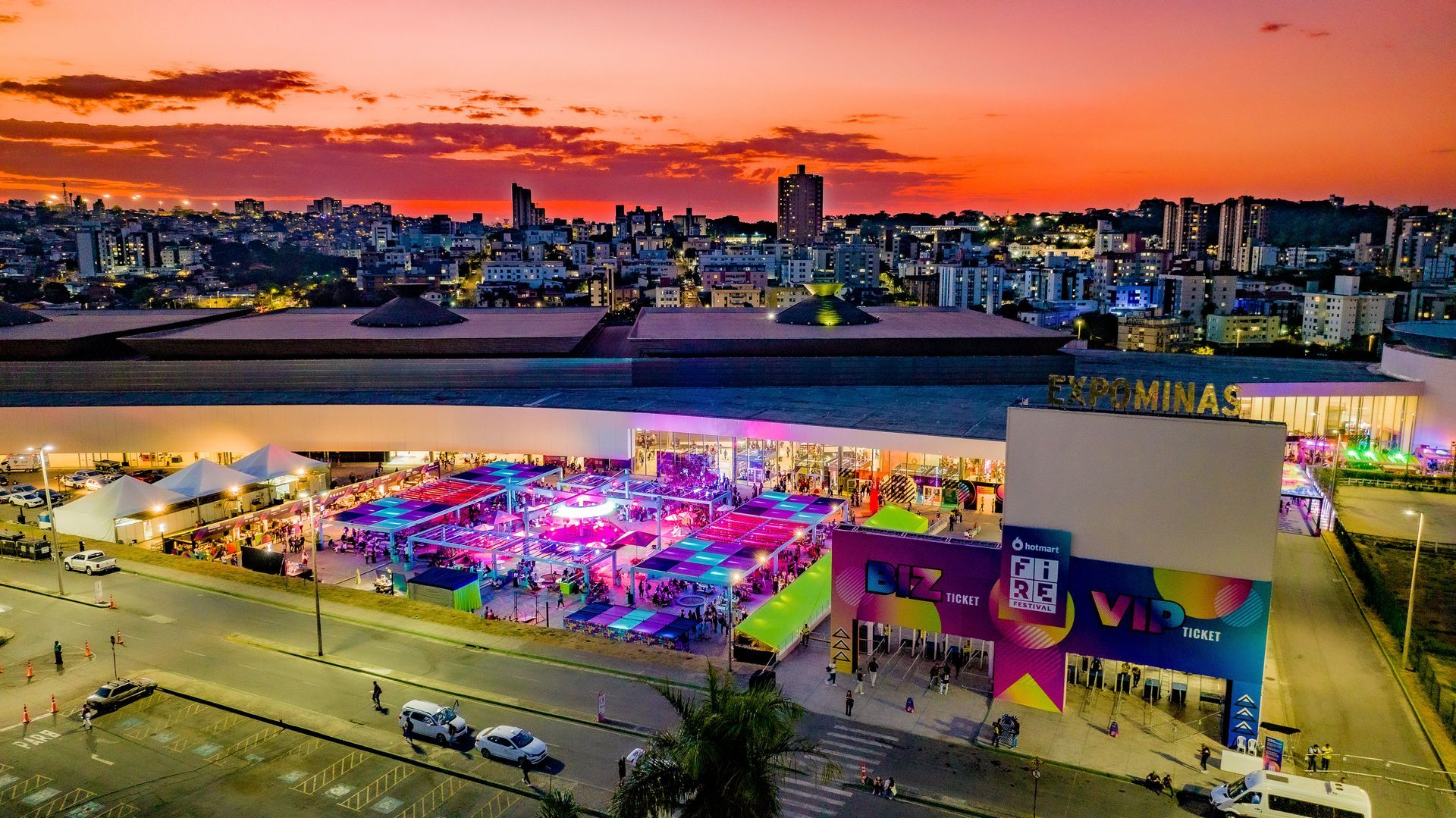 Uma vista aérea de um carnaval com um pôr do sol ao fundo.