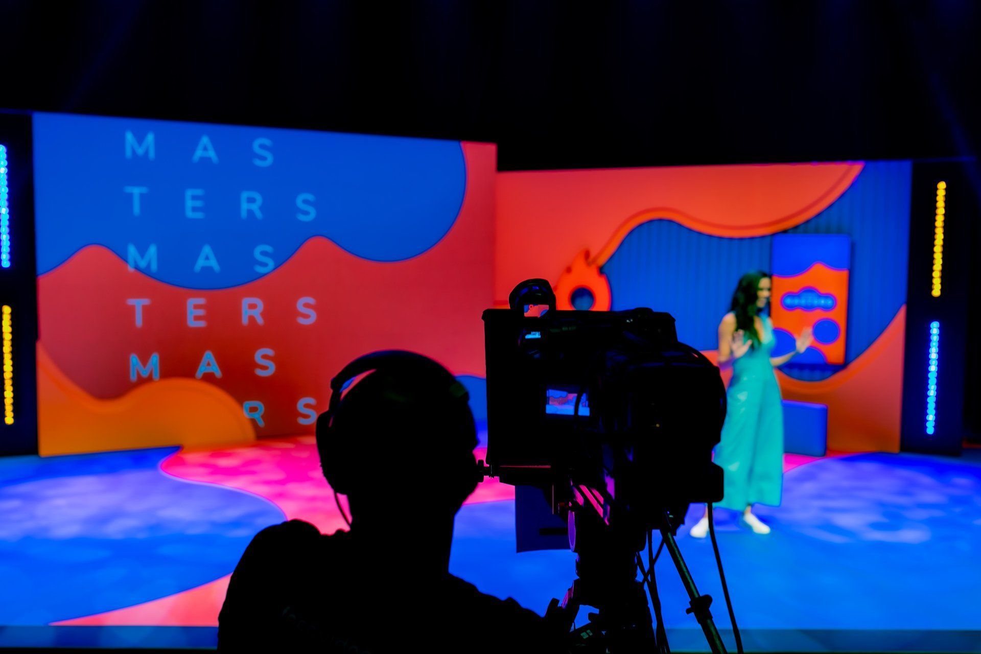 Um cinegrafista está tirando uma foto de uma mulher no palco.