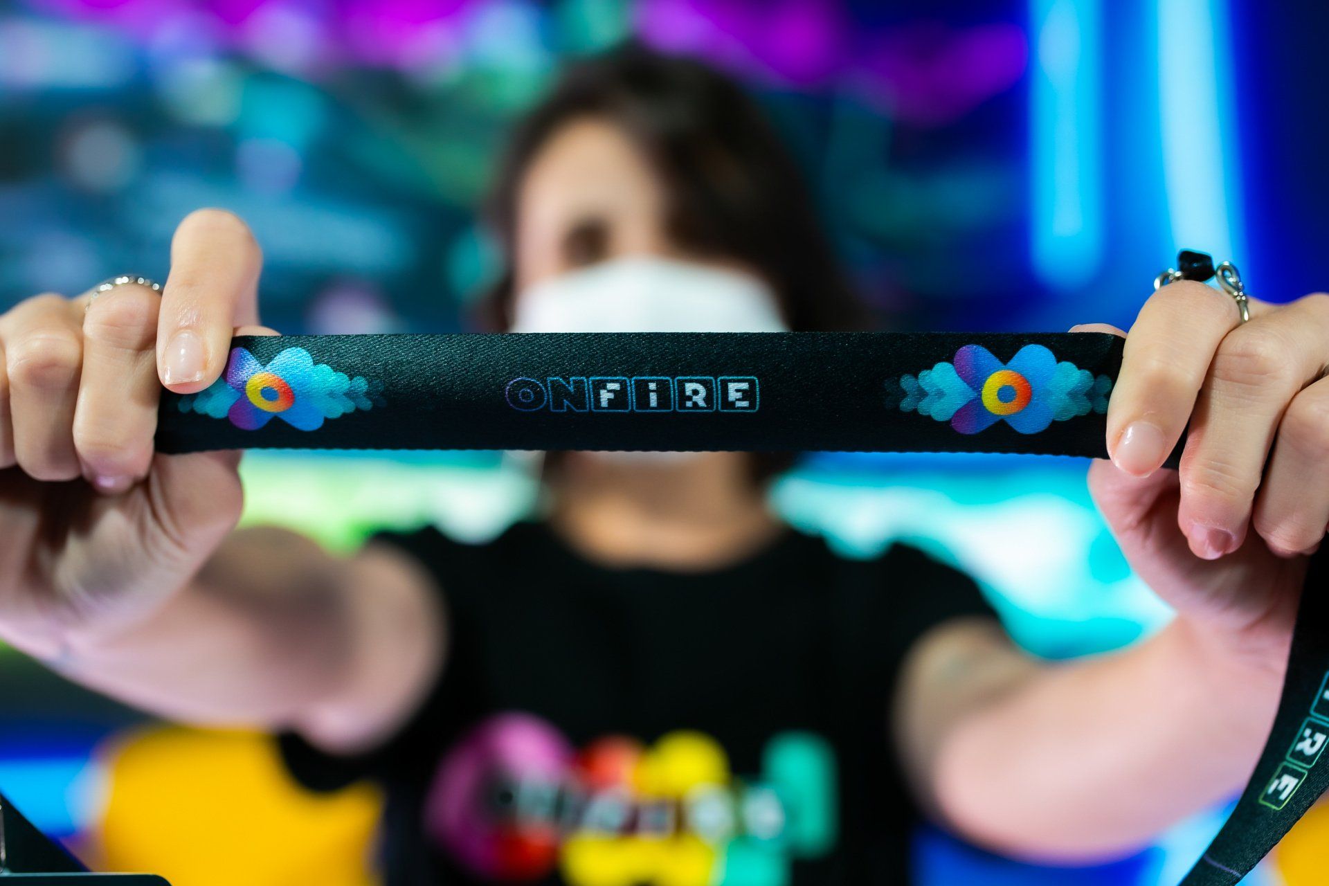 Uma mulher usando uma máscara está segurando um cordão com a palavra spitfire escrita nele.