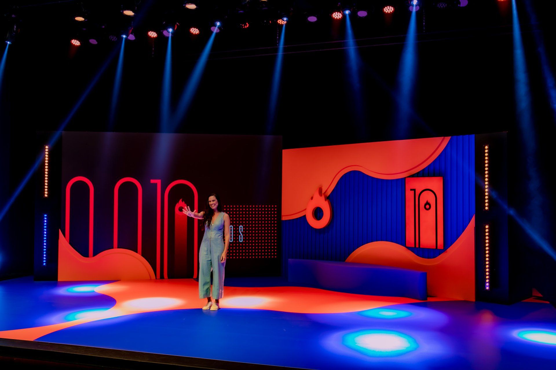 Uma mulher está de pé no palco com um microfone na mão.