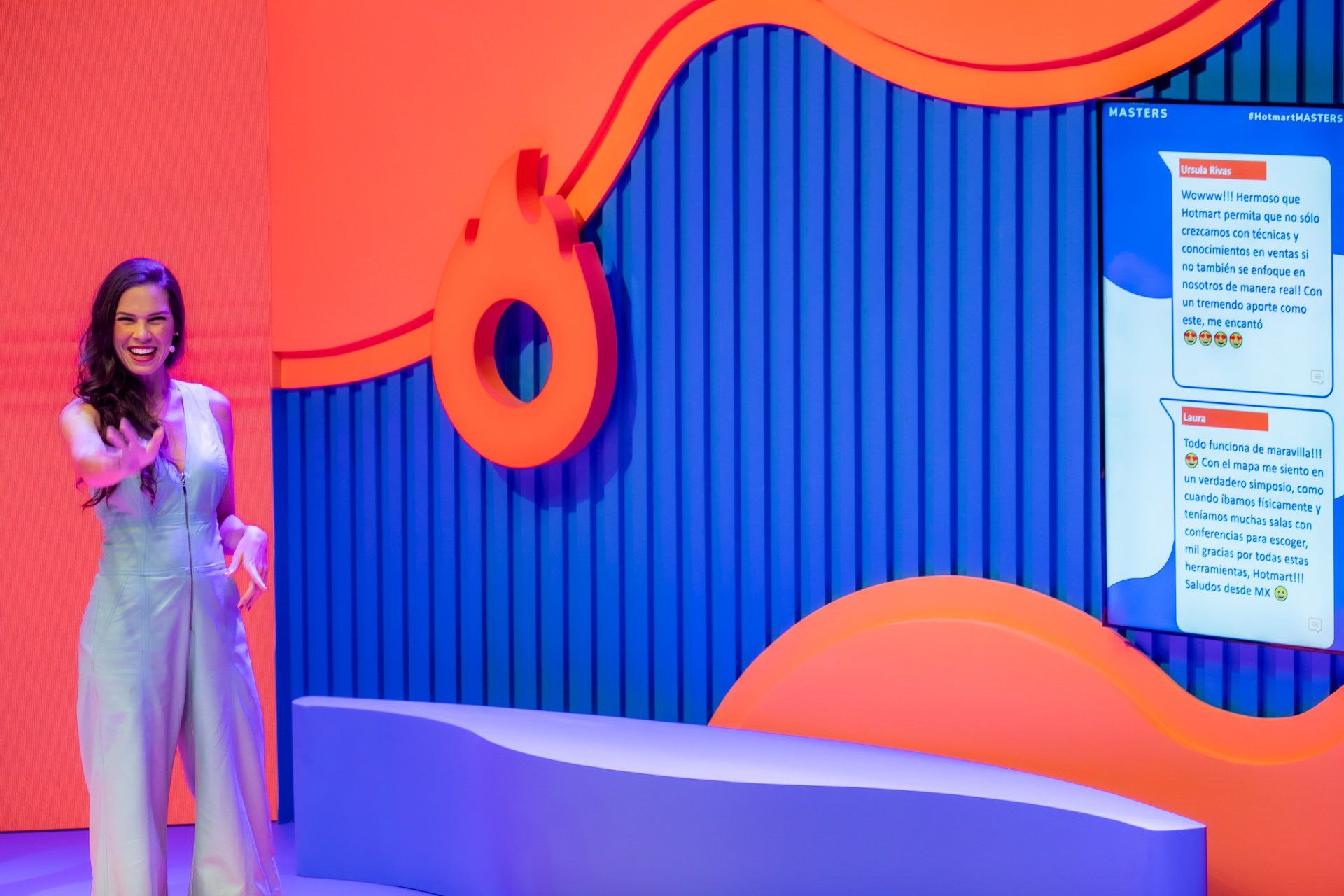 Uma mulher está parada em frente a uma tela grande em uma sala.