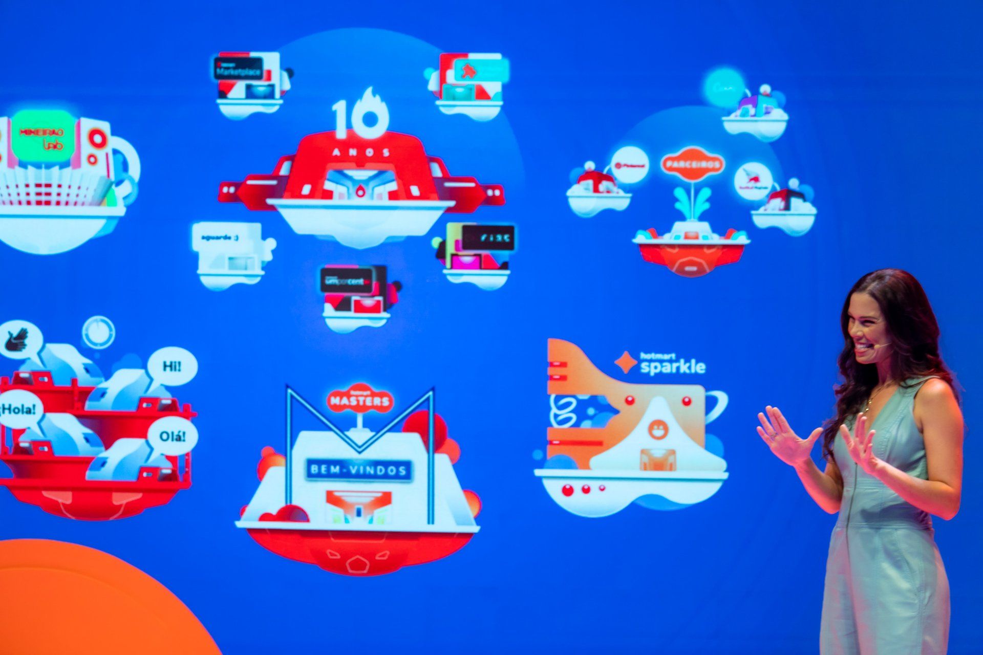 Uma mulher está parada em frente a uma parede azul com muitos ícones nela