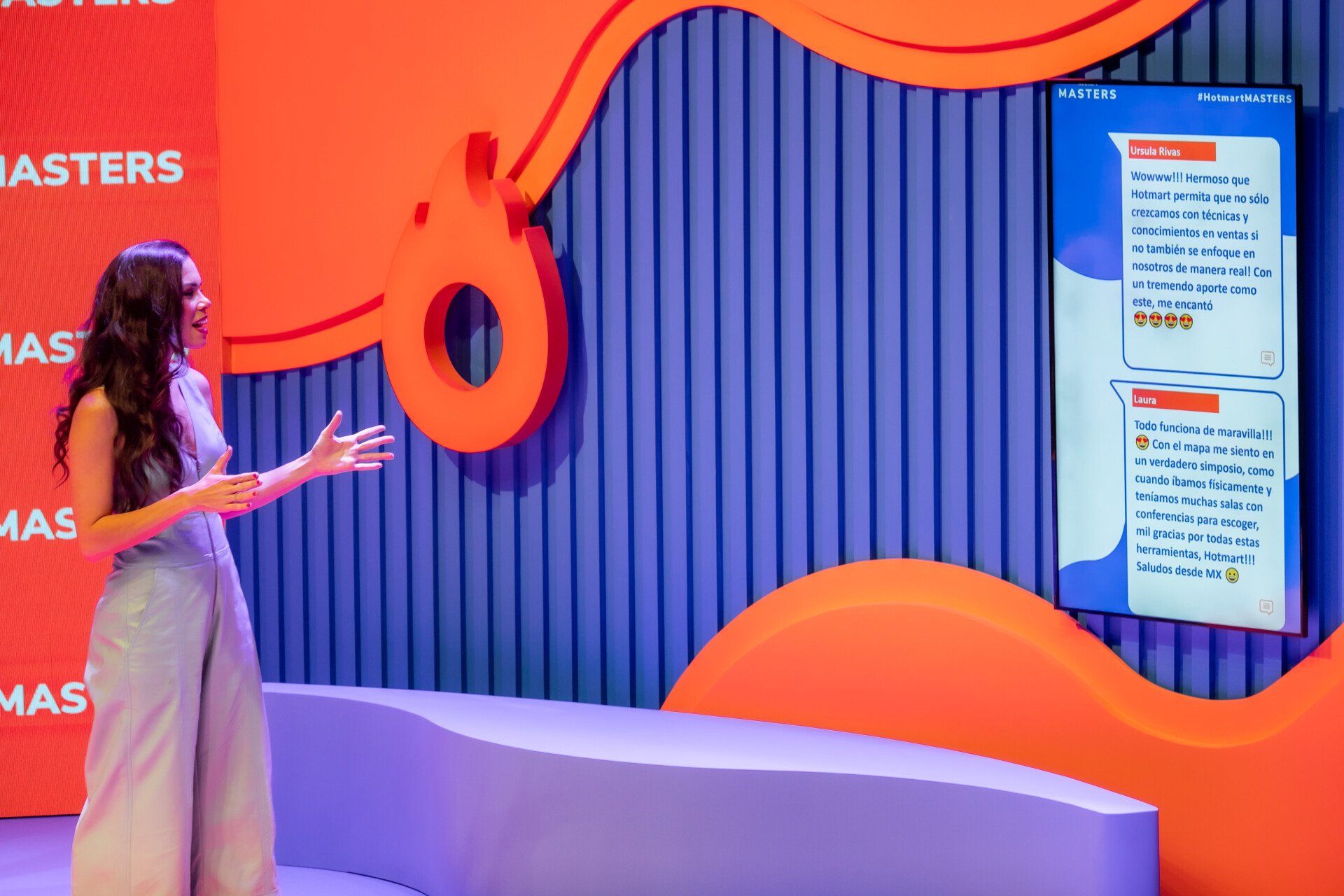 Uma mulher está parada em frente a uma tela grande em uma sala.