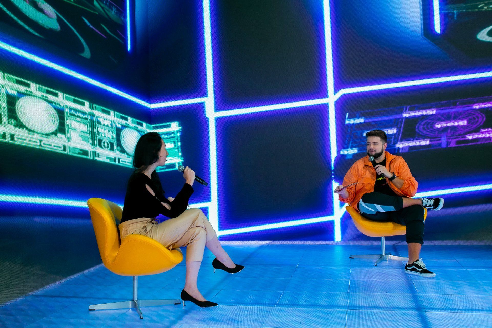 Um homem e uma mulher estão sentados em cadeiras conversando um com o outro.