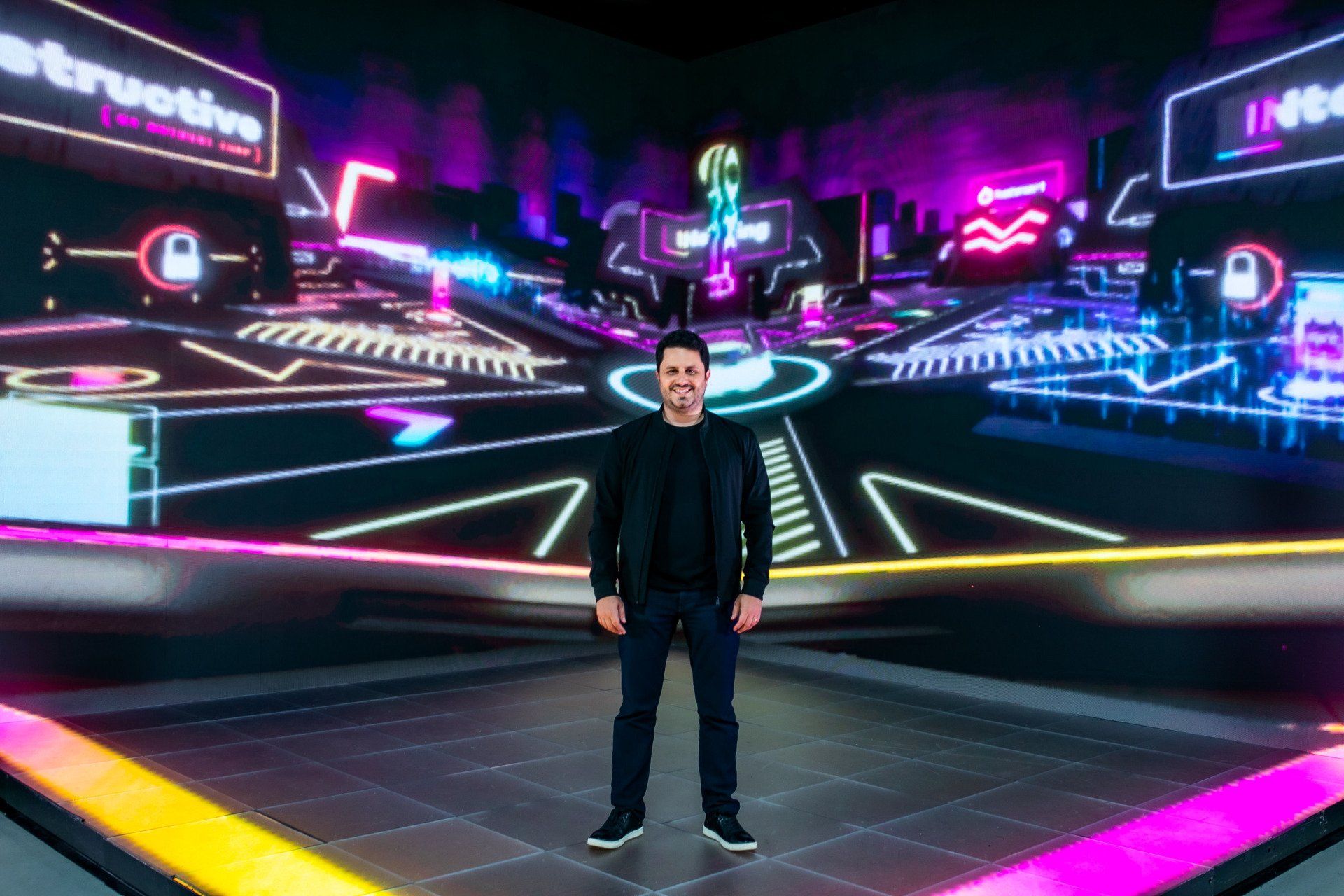 Um homem está parado em frente a uma tela grande.