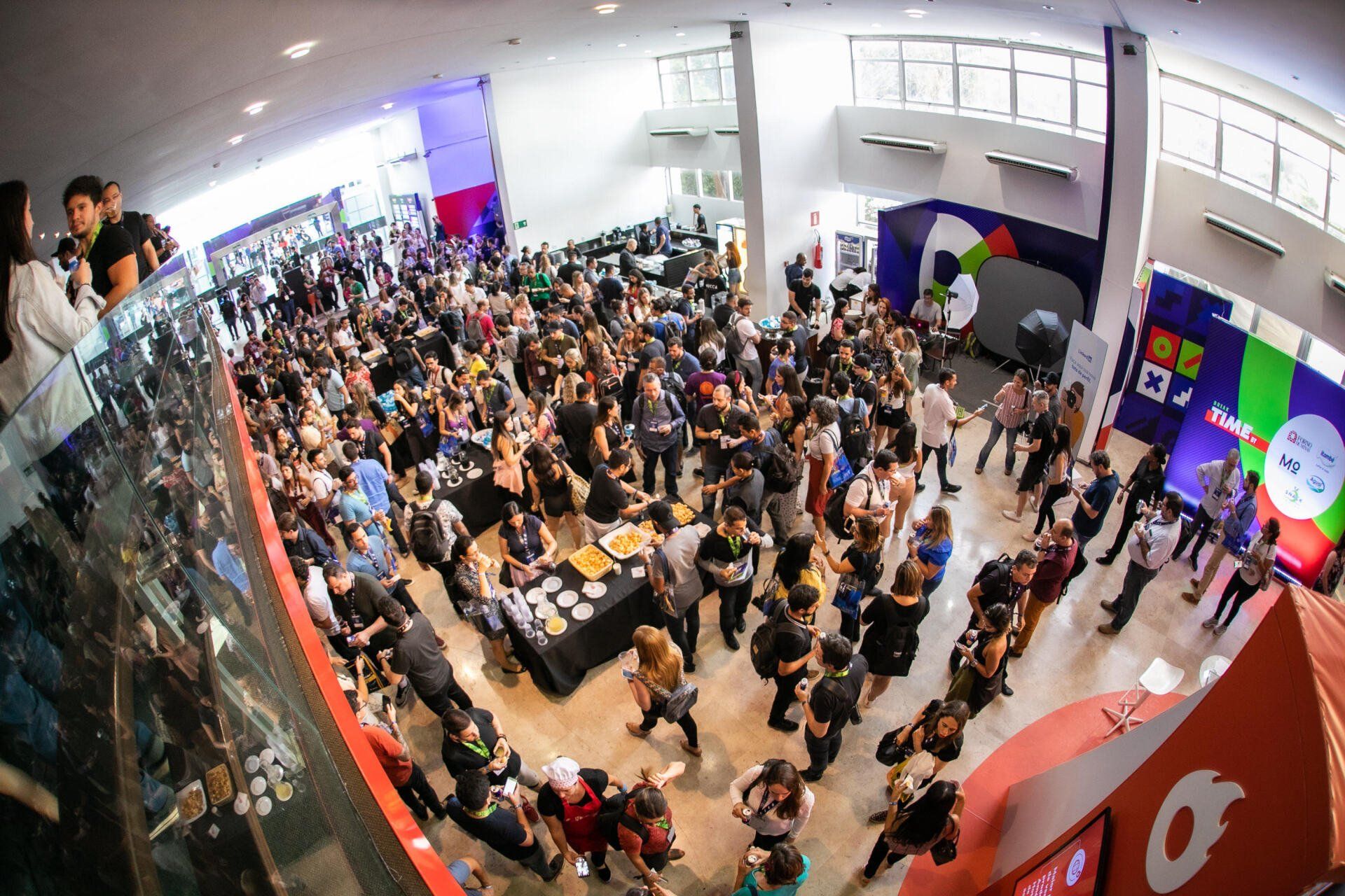 Uma grande multidão de pessoas está reunida em uma grande sala.