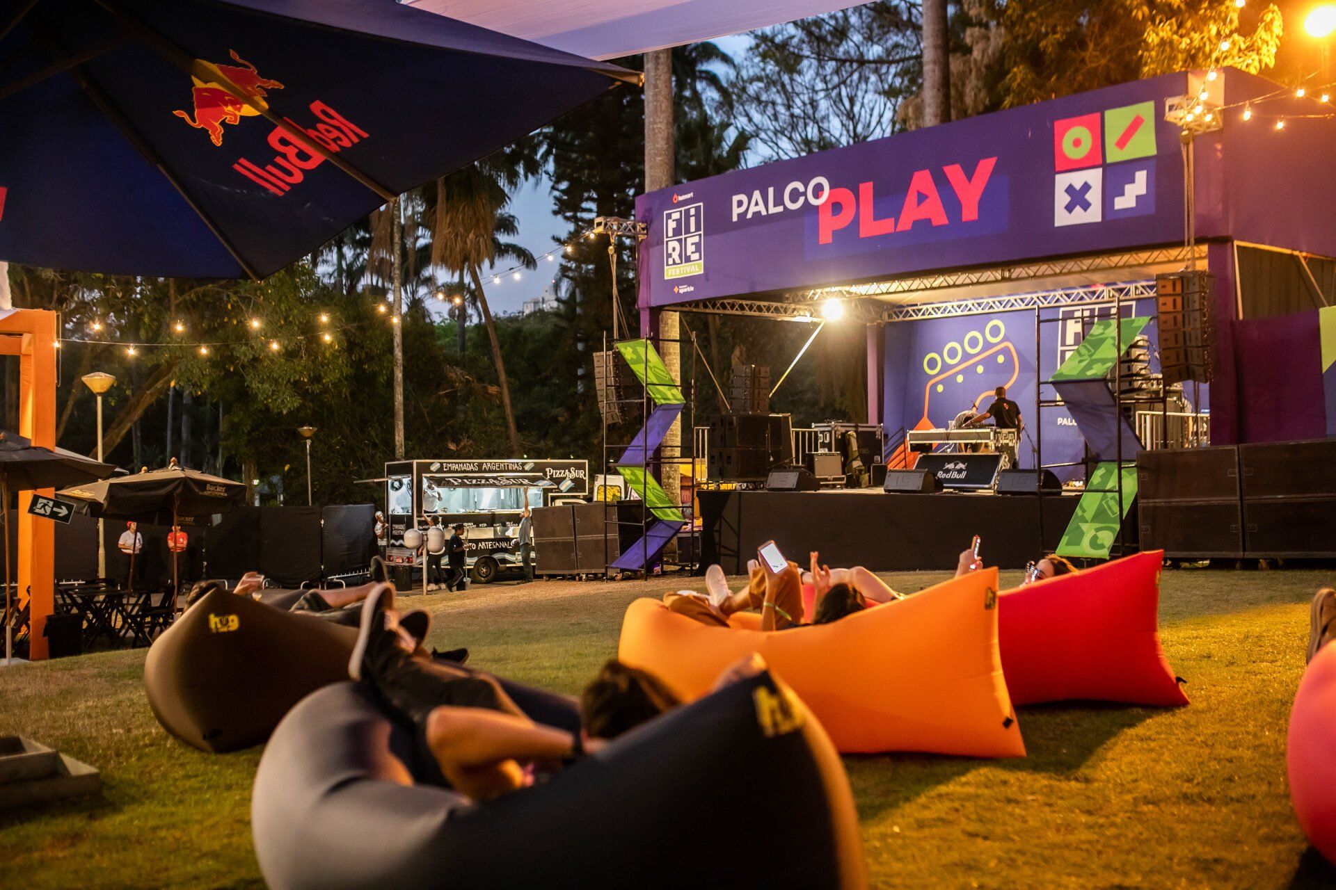 Um grupo de pessoas está sentado em pufes em frente a um palco.