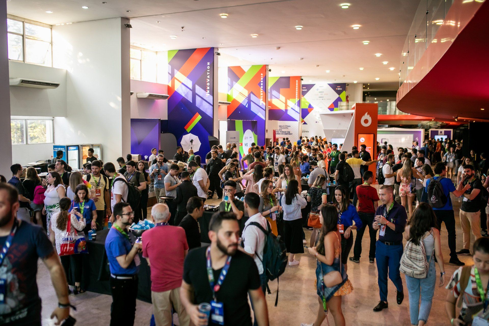 Um grande grupo de pessoas está em uma sala grande.