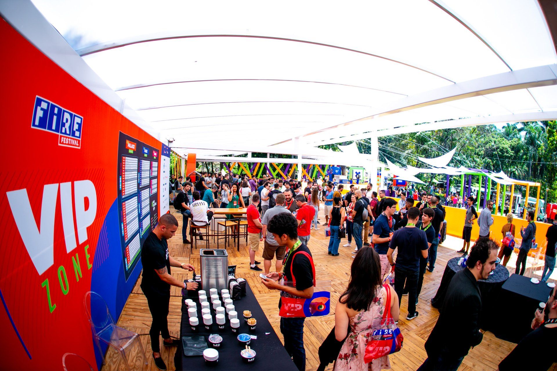 Um grande grupo de pessoas está em volta de uma mesa em uma festa.