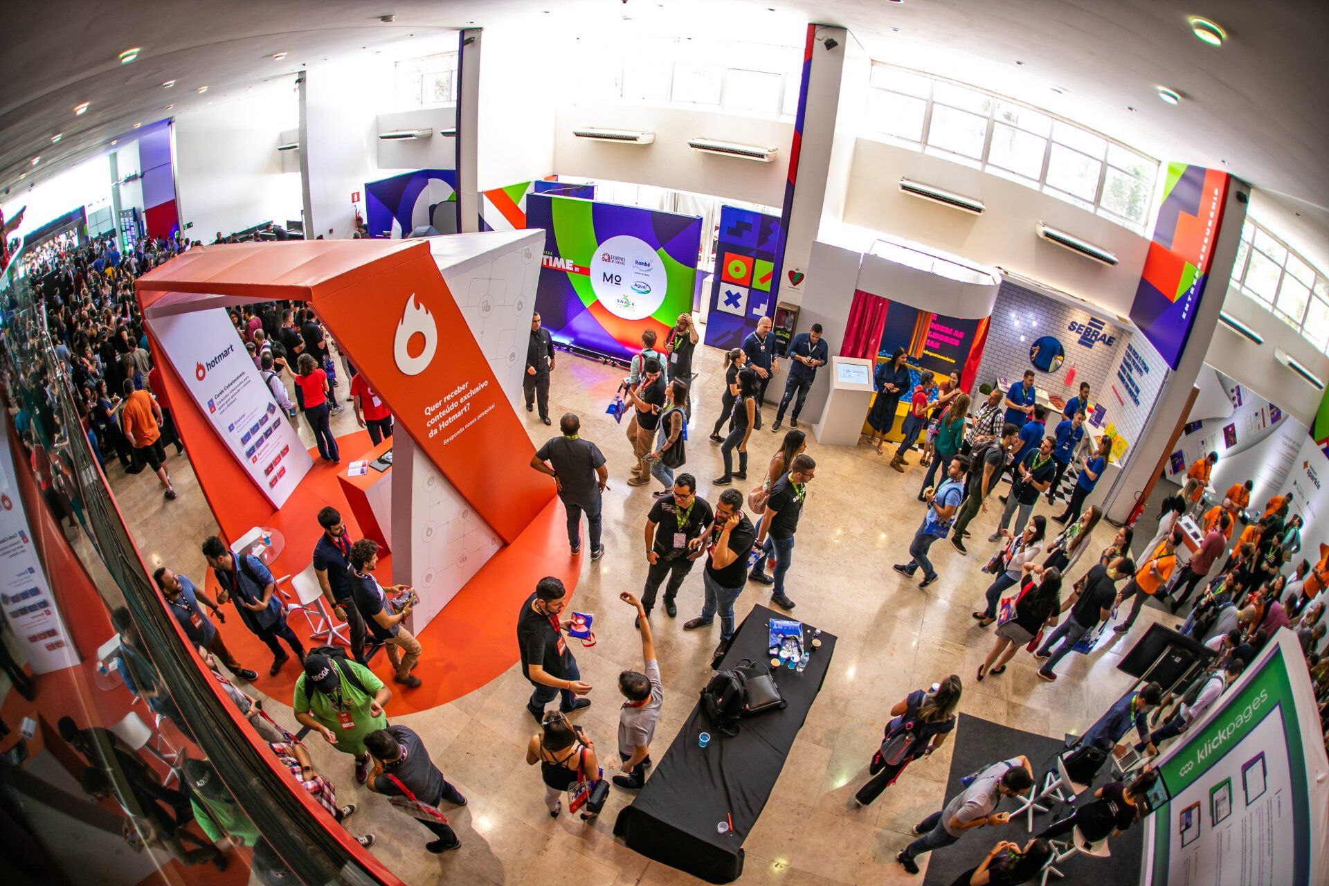 Um grande grupo de pessoas está em uma sala grande.