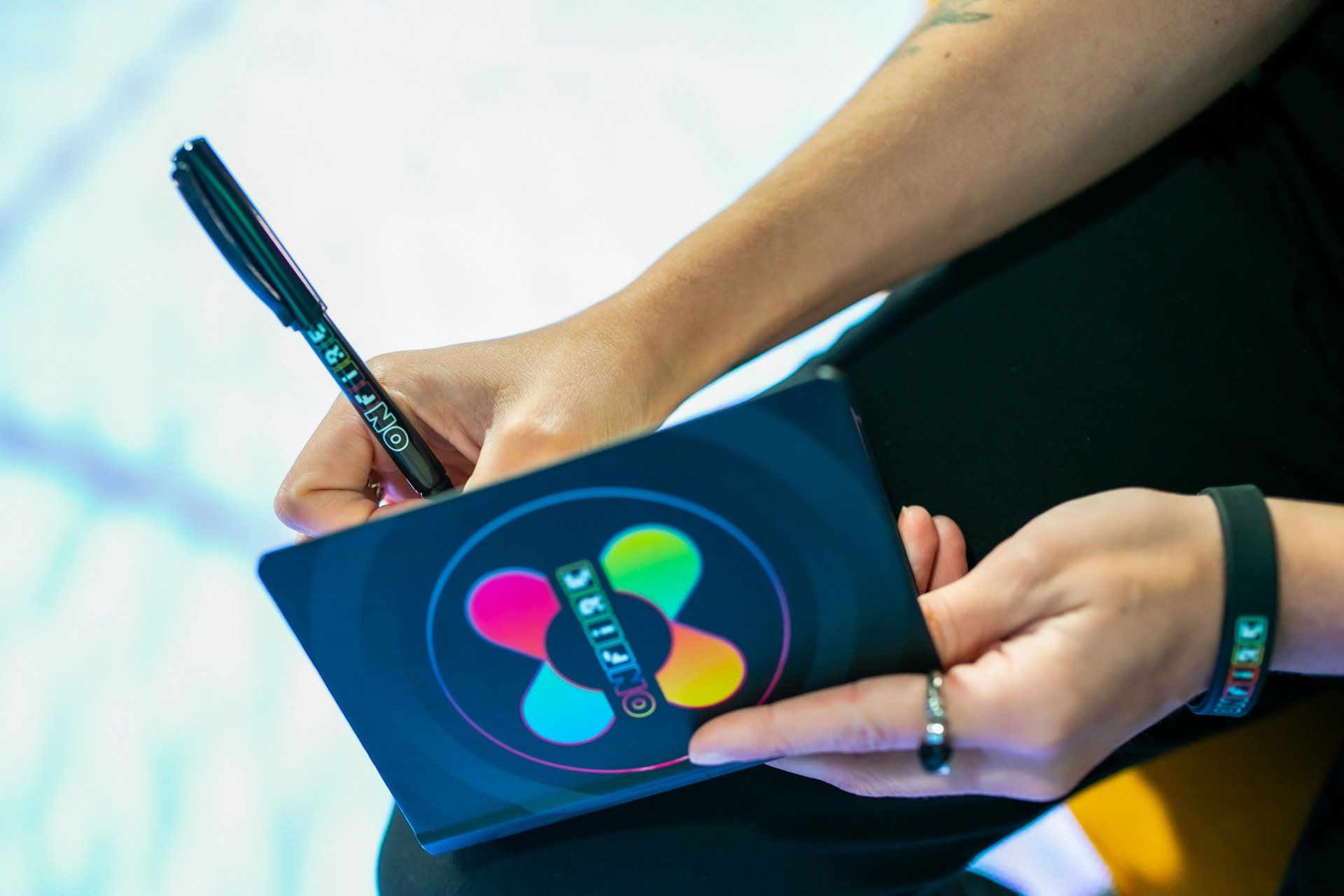 Uma pessoa está escrevendo em um caderno com uma caneta