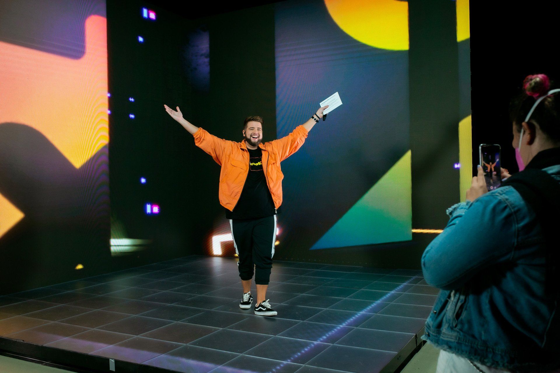 Uma mulher está tirando uma foto de um homem no palco.