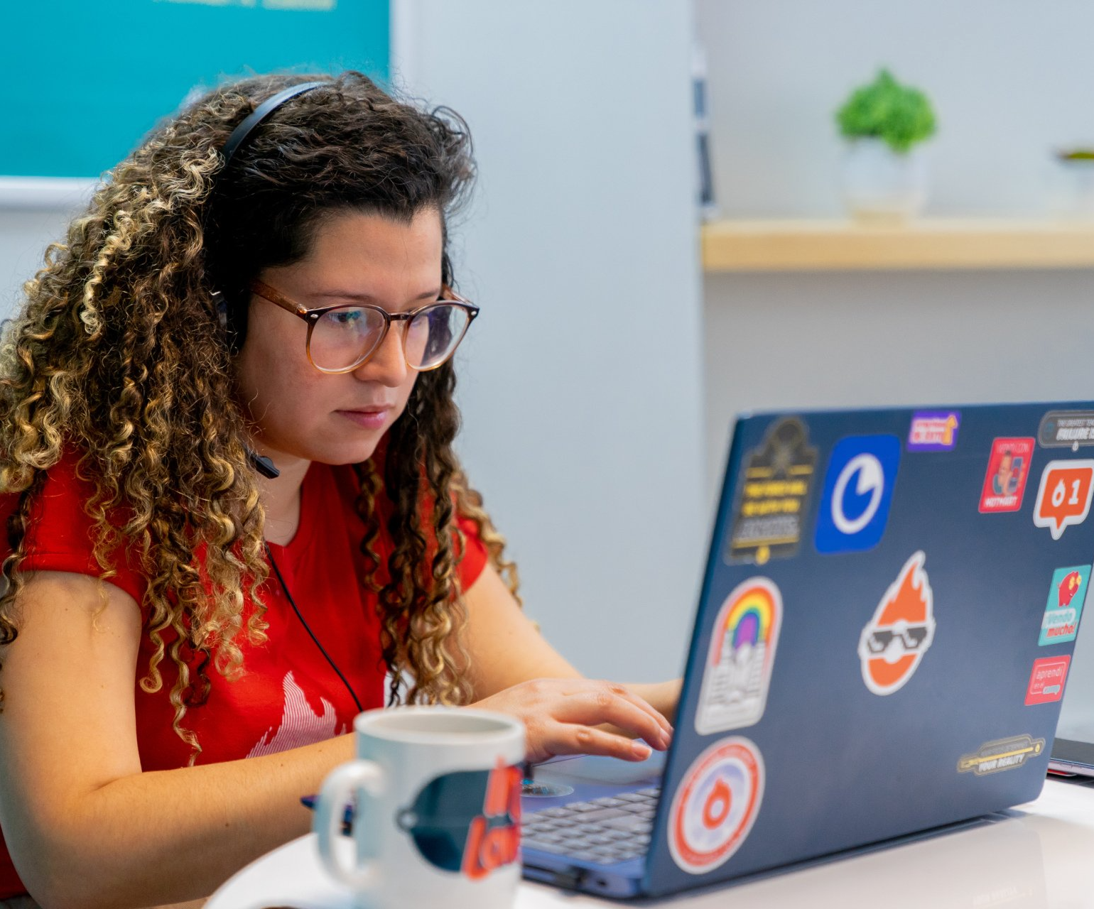 A woman wearing headphones is using a laptop computer.