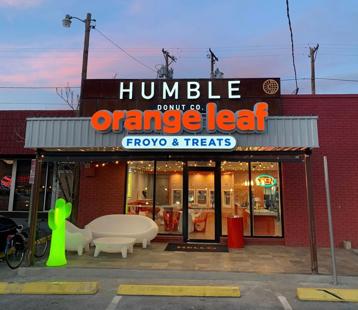An orange leaf restaurant with red chairs and tables