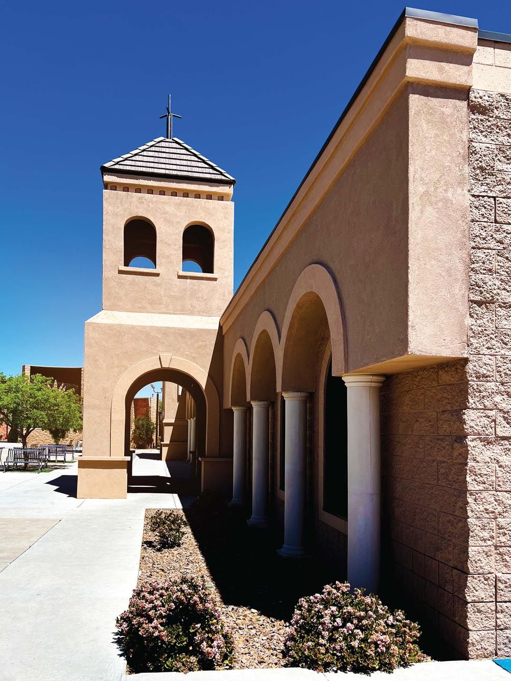 A building with arches and a tower with a cross on top