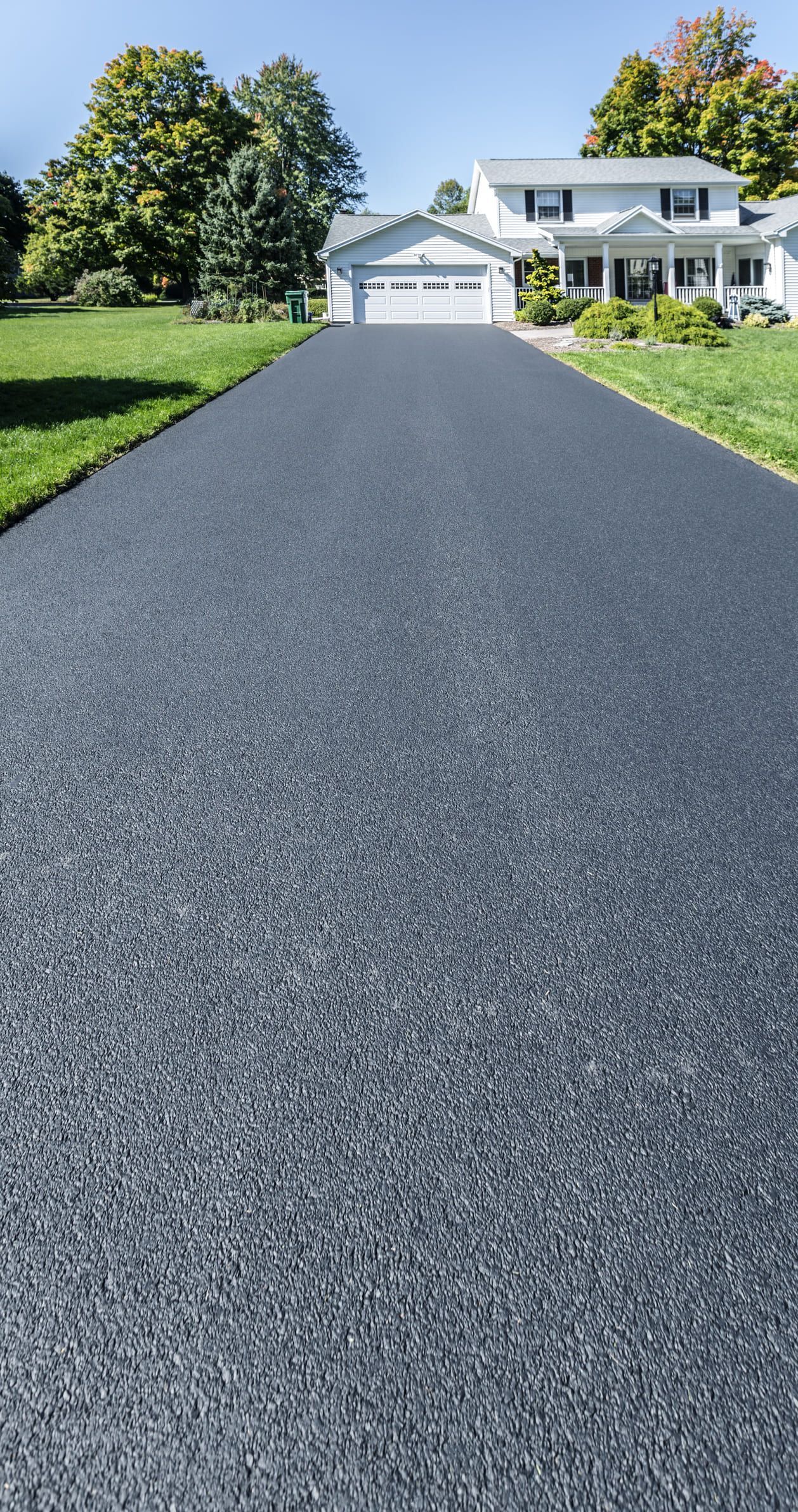 A driveway leading to a house with a garage.