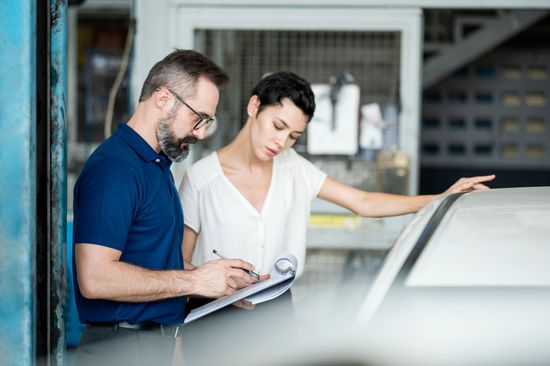 Men explaining damage of car exterior to customer at Freeman Collision Center, for collision repair in Oklahoma City, OK