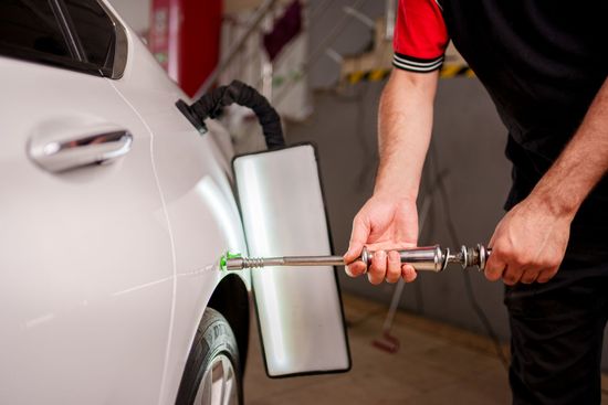 Men repairing car dent after accident at Freeman Collision Center, offering collision repair services in Oklahoma City, OK