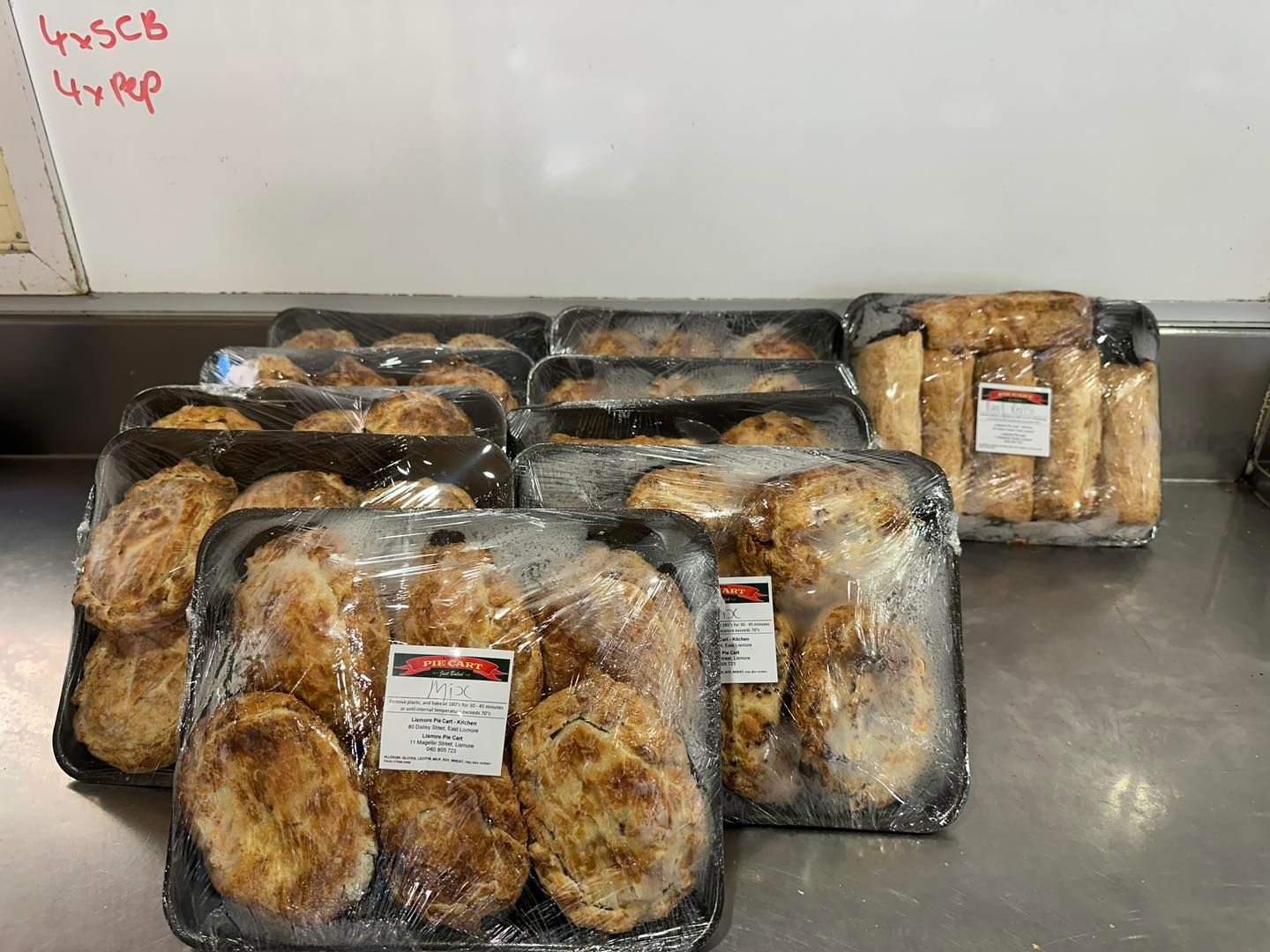 A Bunch of Trays of Food Are Sitting on a Counter — Lismore Pie Cart in Lismore, NSW