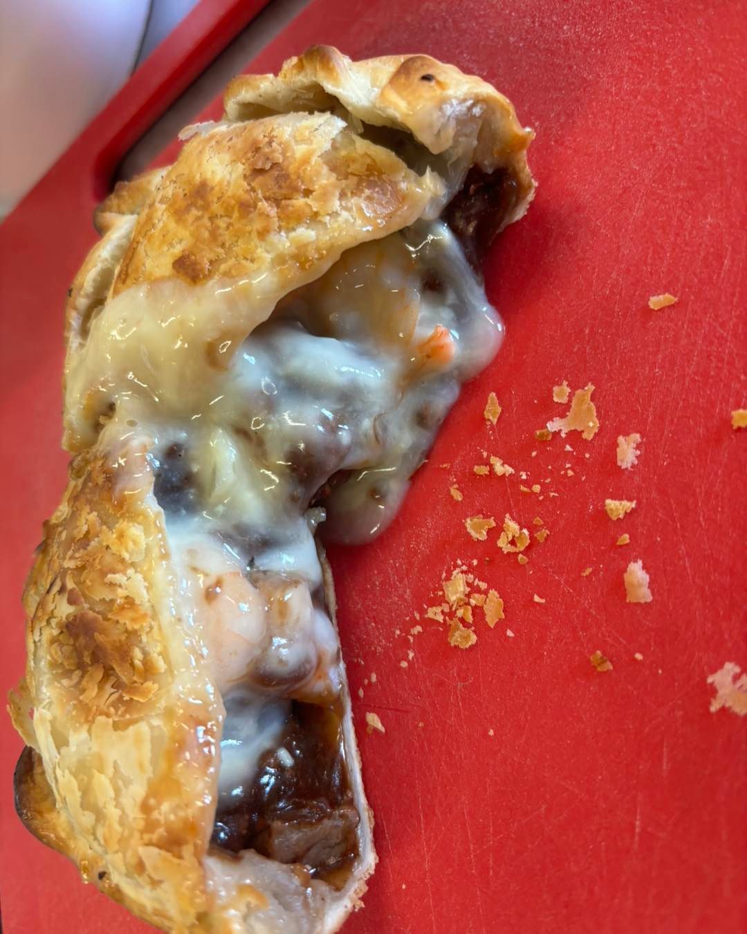 A Close Up of a Pie on a Red Cutting Board — Lismore Pie Cart in Lismore, NSW